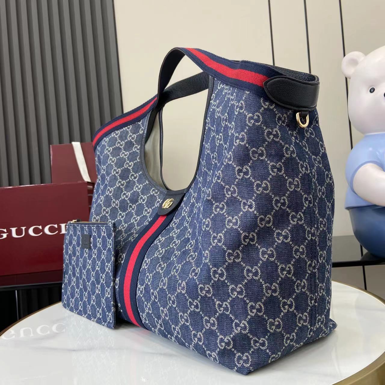 p580。《配全套原厂专柜包装》【新品】Gucci Giglio系列全新亮相佛罗伦萨2026早春时装秀，致敬品牌意式根源，融合隽永传承与革新精神。这款大容量托特包采用GG丹宁面料匠心打造，缀饰织带滚边，并配有一个可拆卸的手拿包。
蓝色和白色GG丹宁
饰蓝红织带滚边
浅金色调配件
棕色棉布衬里
双G
配可拆卸手拿包
顶部提手：18厘米高
磁扣开合
型号：853971。
尺寸60厘米（宽） x 47厘米（高） x 16厘米（深）
重量：约0.6千克
颜色：蓝牛仔/蓝皮。
意大利创作