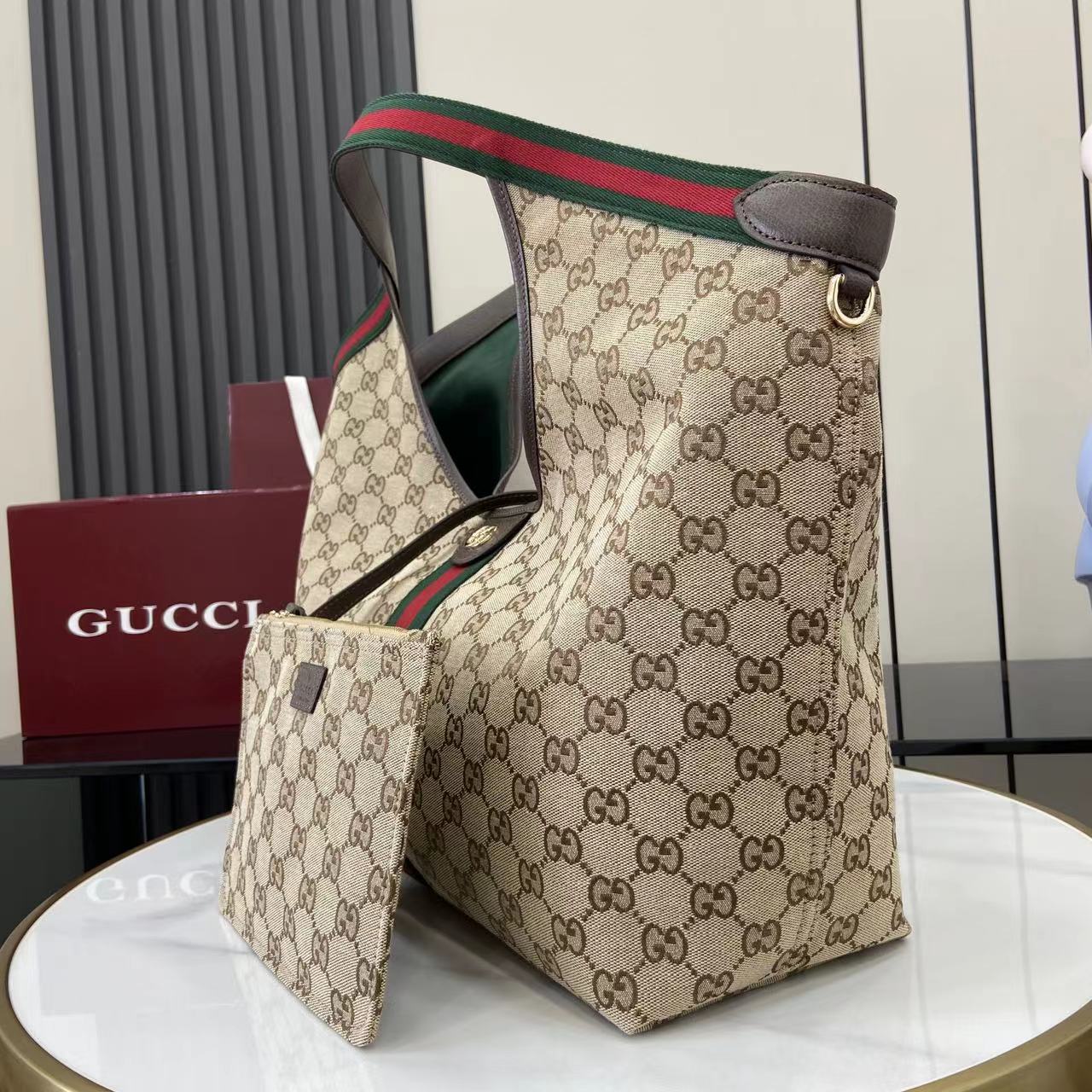 p580。《配全套原厂专柜包装》【新品】Gucci Giglio系列全新亮相佛罗伦萨2026早春时装秀，致敬品牌意式根源，融合隽永传承与革新精神。这款大容量托特包采用GG帆布匠心打造，缀饰织带滚边，并配有一个可拆卸的手拿包。
米白和深棕色GG帆布
饰红绿织带滚边
绿色棉布衬里
双G
配可拆卸手拿包
顶部提手：18厘米高
磁扣开合
型号：853971。
尺寸：60厘米（宽） x 47厘米（高） x 16厘米（深）
重量：约0.6千克
颜色：杏布/棕色。
意大利创作