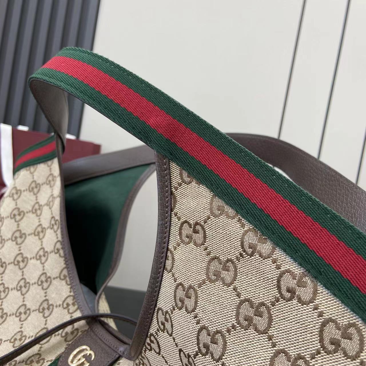 p580。《配全套原厂专柜包装》【新品】Gucci Giglio系列全新亮相佛罗伦萨2026早春时装秀，致敬品牌意式根源，融合隽永传承与革新精神。这款大容量托特包采用GG帆布匠心打造，缀饰织带滚边，并配有一个可拆卸的手拿包。
米白和深棕色GG帆布
饰红绿织带滚边
绿色棉布衬里
双G
配可拆卸手拿包
顶部提手：18厘米高
磁扣开合
型号：853971。
尺寸：60厘米（宽） x 47厘米（高） x 16厘米（深）
重量：约0.6千克
颜色：杏布/棕色。
意大利创作