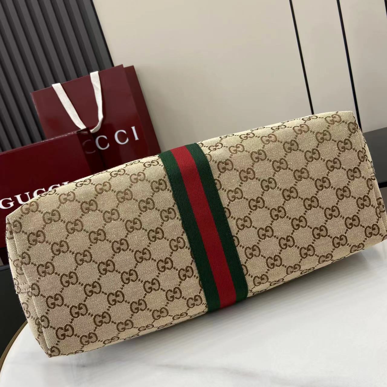 p580。《配全套原厂专柜包装》【新品】Gucci Giglio系列全新亮相佛罗伦萨2026早春时装秀，致敬品牌意式根源，融合隽永传承与革新精神。这款大容量托特包采用GG帆布匠心打造，缀饰织带滚边，并配有一个可拆卸的手拿包。
米白和深棕色GG帆布
饰红绿织带滚边
绿色棉布衬里
双G
配可拆卸手拿包
顶部提手：18厘米高
磁扣开合
型号：853971。
尺寸：60厘米（宽） x 47厘米（高） x 16厘米（深）
重量：约0.6千克
颜色：杏布/棕色。
意大利创作