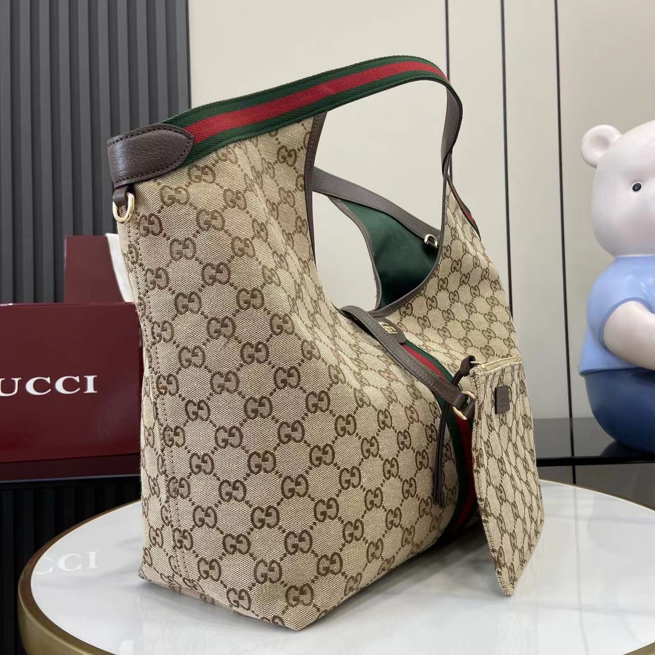 p580。《配全套原厂专柜包装》【新品】Gucci Giglio系列全新亮相佛罗伦萨2026早春时装秀，致敬品牌意式根源，融合隽永传承与革新精神。这款大容量托特包采用GG帆布匠心打造，缀饰织带滚边，并配有一个可拆卸的手拿包。
米白和深棕色GG帆布
饰红绿织带滚边
绿色棉布衬里
双G
配可拆卸手拿包
顶部提手：18厘米高
磁扣开合
型号：853971。
尺寸：60厘米（宽） x 47厘米（高） x 16厘米（深）
重量：约0.6千克
颜色：杏布/棕色。
意大利创作