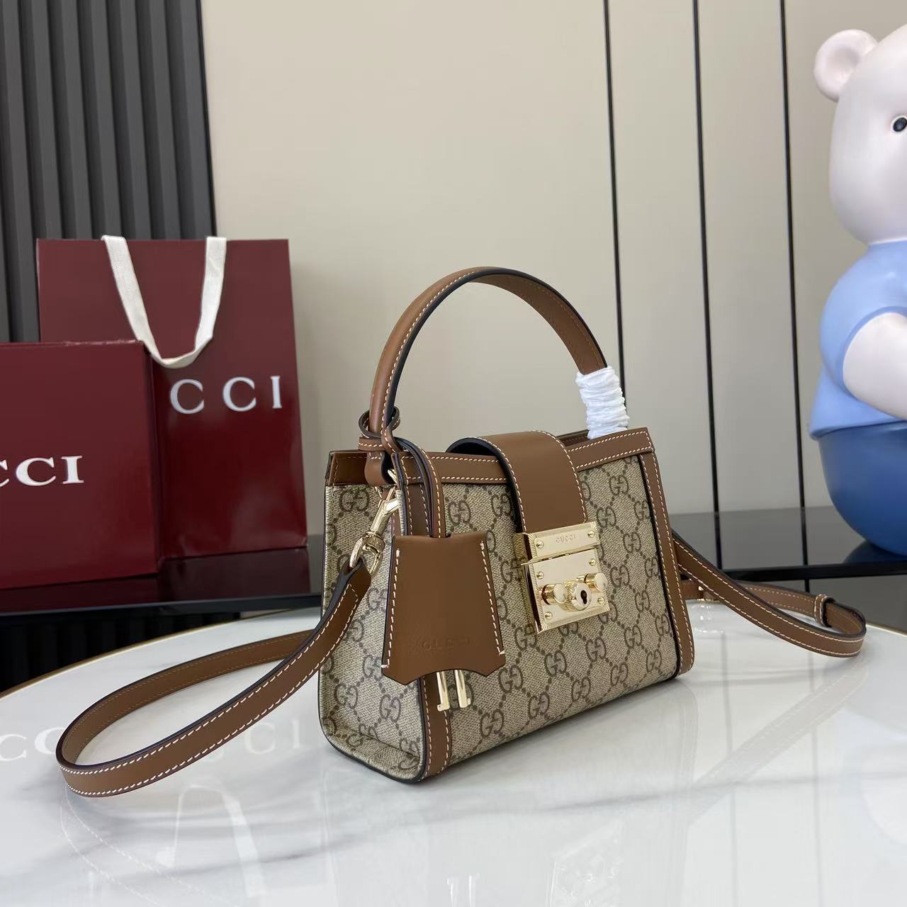 p550。《配全套原厂专柜包装》【新品】Padlock系列以现代廓形惊艳亮相2025早秋系列，解锁多种背携方式。此款式手提或斜挎皆宜，织带衬里致敬品牌标志性元素。
米色和深棕色GG字母交织图案涂层织物
棕色皮革滚边
浅金色调配件
红绿织带棉布衬里
内部：一个开口袋
外部：一个开口袋
挂锁锁扣，配有皮革钥匙扣
型号：841653。
尺寸：20厘米（宽）x 13.5厘米（高）x 8厘米（深）
重量：约0.6千克
颜色：啡棕/pvc。
