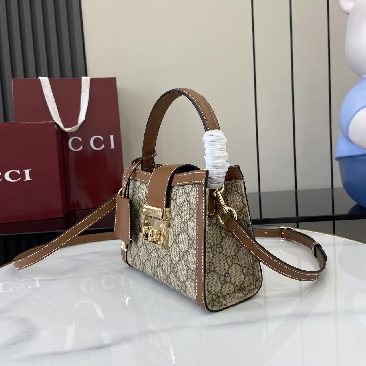 p550。《配全套原厂专柜包装》【新品】Padlock系列以现代廓形惊艳亮相2025早秋系列，解锁多种背携方式。此款式手提或斜挎皆宜，织带衬里致敬品牌标志性元素。
米色和深棕色GG字母交织图案涂层织物
棕色皮革滚边
浅金色调配件
红绿织带棉布衬里
内部：一个开口袋
外部：一个开口袋
挂锁锁扣，配有皮革钥匙扣
型号：841653。
尺寸：20厘米（宽）x 13.5厘米（高）x 8厘米（深）
重量：约0.6千克
颜色：啡棕/pvc。