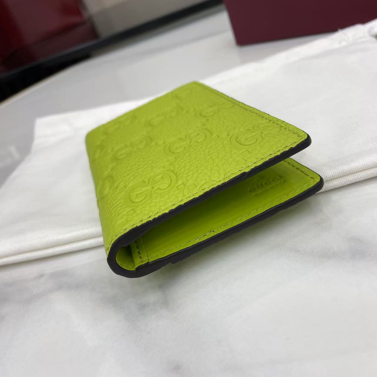 p180。《配全套原厂专柜包装》【新品】系列名称“Gucci Imprint”尽释GG字母交织图案的恒久优雅魅力，该图案以富有触感的细节装点日常风格单品。这款卡片夹以印花压纹GG粒面牛皮革打造，巧妙融入同色调云纹织物衬里。
荧光绿色印花压纹GG粒面牛皮革
荧光绿色云纹织物衬里
内部：八个卡片隔层和两个隐形隔层
外部：一个卡片隔层
型号：835011。
尺寸：12厘米（宽）x 7.5厘米（高）
重量：约70克
颜色：荧光绿色压花。
意大利创作