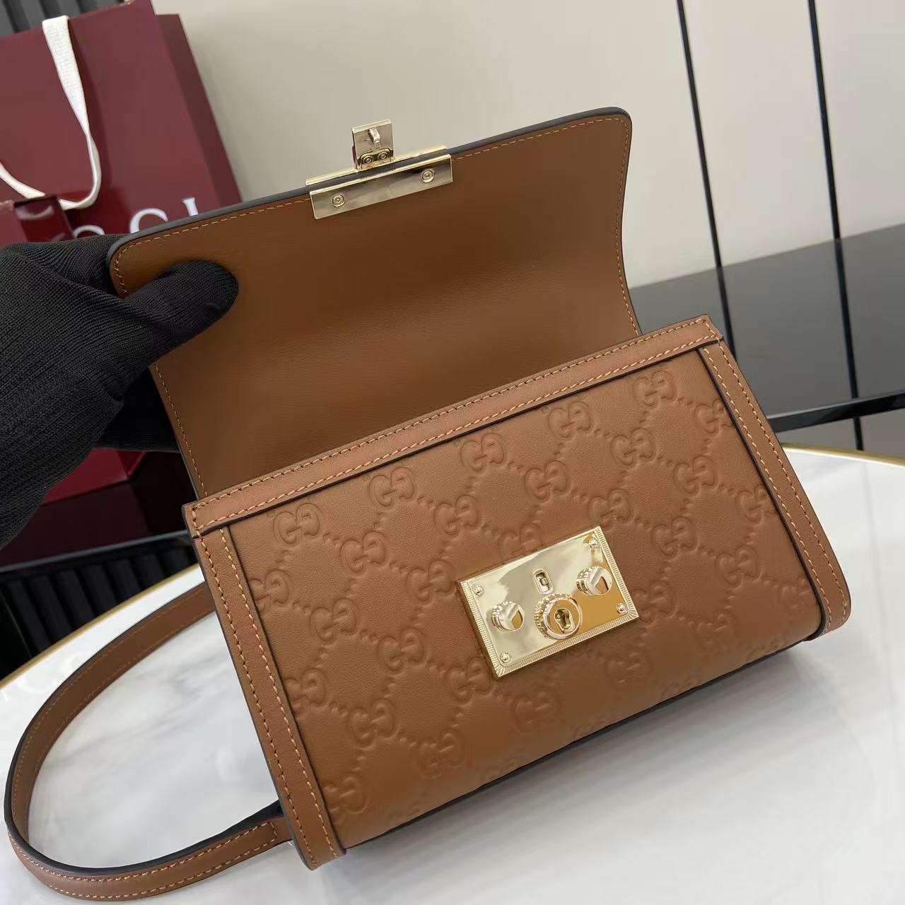 p640。《配全套原厂专柜包装》【新品】Padlock系列以现代廓形惊艳亮相2025早秋系列，解锁多种背携方式。此款式手提或斜挎皆宜，织带衬里致敬品牌标志性元素。
棕色GG字母交织图案涂层织物
棕色皮革滚边
浅金色调配件
棕色棉布衬里
内部：一个开口袋
外部：一个开口袋
提手（6厘米高）
可拆卸可调节皮革肩带（高度：57厘米 – 62厘米；长度：103厘米 – 123厘米）
挂锁锁扣，配有皮革钥匙扣
型号：848884。
尺寸：20厘米（宽）x 13厘米（高）x 8厘米（深）
重量：约0.6千克
颜色：棕色/压花。
意大利创作
