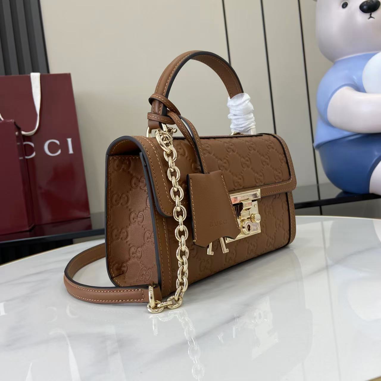 p640。《配全套原厂专柜包装》【新品】Padlock系列以现代廓形惊艳亮相2025早秋系列，解锁多种背携方式。此款式手提或斜挎皆宜，织带衬里致敬品牌标志性元素。
棕色GG字母交织图案涂层织物
棕色皮革滚边
浅金色调配件
棕色棉布衬里
内部：一个开口袋
外部：一个开口袋
提手（6厘米高）
可拆卸可调节皮革肩带（高度：57厘米 – 62厘米；长度：103厘米 – 123厘米）
挂锁锁扣，配有皮革钥匙扣
型号：848884。
尺寸：20厘米（宽）x 13厘米（高）x 8厘米（深）
重量：约0.6千克
颜色：棕色/压花。
意大利创作