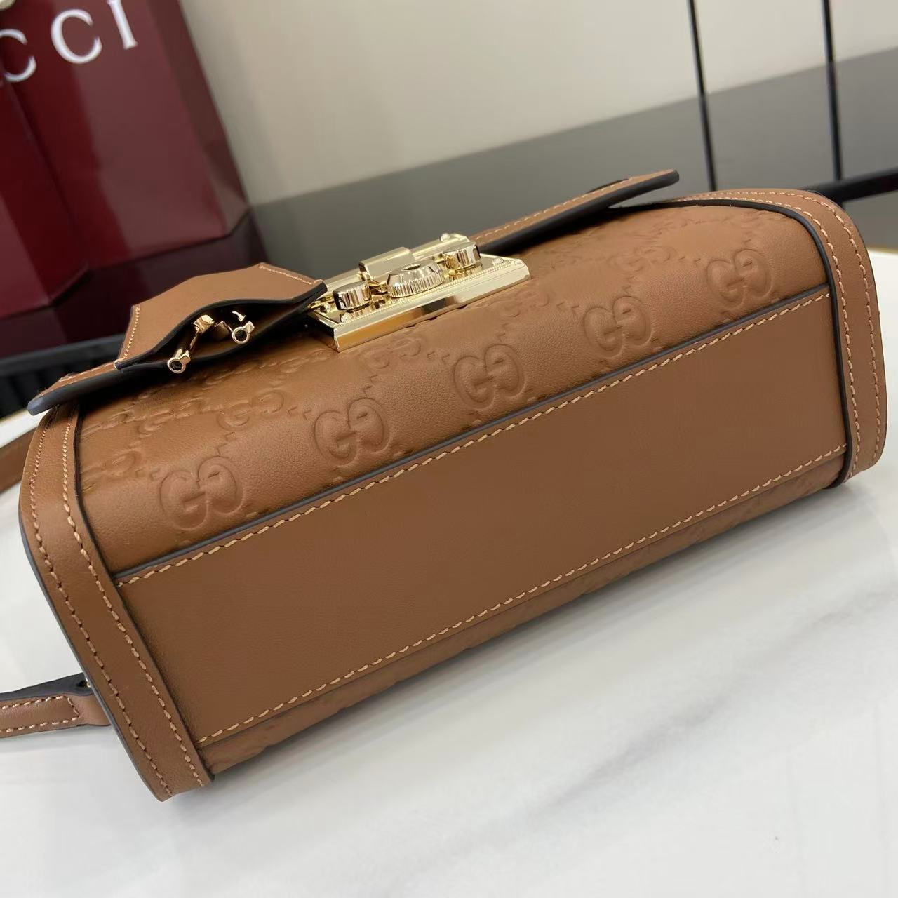 p640。《配全套原厂专柜包装》【新品】Padlock系列以现代廓形惊艳亮相2025早秋系列，解锁多种背携方式。此款式手提或斜挎皆宜，织带衬里致敬品牌标志性元素。
棕色GG字母交织图案涂层织物
棕色皮革滚边
浅金色调配件
棕色棉布衬里
内部：一个开口袋
外部：一个开口袋
提手（6厘米高）
可拆卸可调节皮革肩带（高度：57厘米 – 62厘米；长度：103厘米 – 123厘米）
挂锁锁扣，配有皮革钥匙扣
型号：848884。
尺寸：20厘米（宽）x 13厘米（高）x 8厘米（深）
重量：约0.6千克
颜色：棕色/压花。
意大利创作