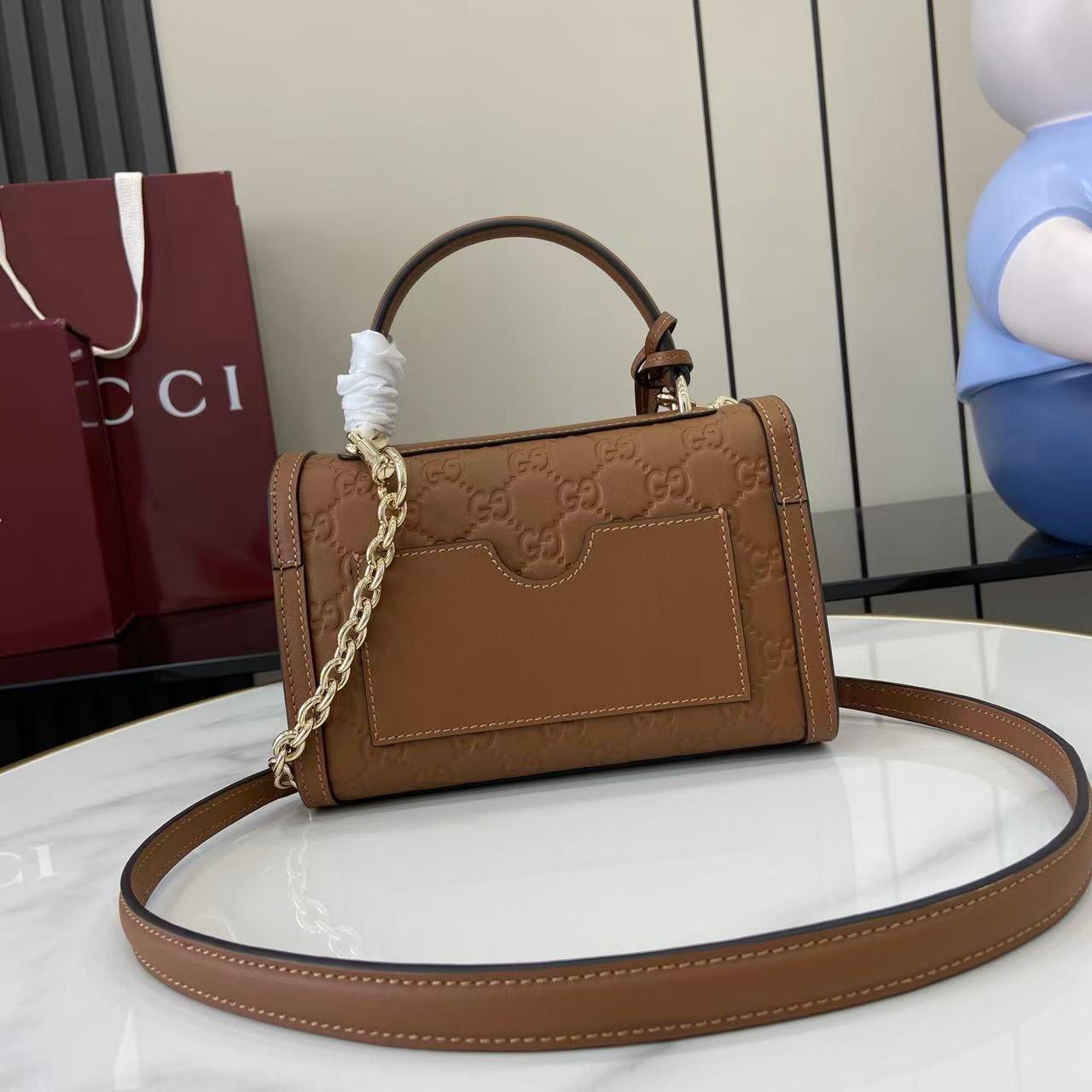 p640。《配全套原厂专柜包装》【新品】Padlock系列以现代廓形惊艳亮相2025早秋系列，解锁多种背携方式。此款式手提或斜挎皆宜，织带衬里致敬品牌标志性元素。
棕色GG字母交织图案涂层织物
棕色皮革滚边
浅金色调配件
棕色棉布衬里
内部：一个开口袋
外部：一个开口袋
提手（6厘米高）
可拆卸可调节皮革肩带（高度：57厘米 – 62厘米；长度：103厘米 – 123厘米）
挂锁锁扣，配有皮革钥匙扣
型号：848884。
尺寸：20厘米（宽）x 13厘米（高）x 8厘米（深）
重量：约0.6千克
颜色：棕色/压花。
意大利创作