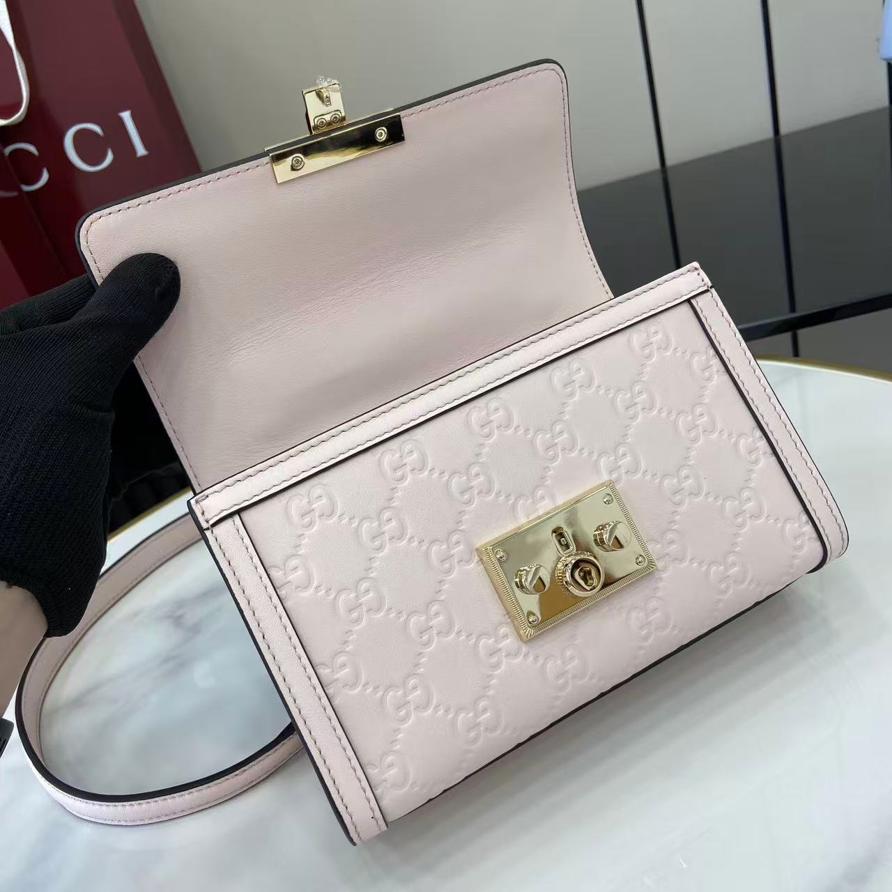 p640。《配全套原厂专柜包装》【新品】Padlock系列以现代廓形惊艳亮相2025早秋系列，解锁多种背携方式。此款式手提或斜挎皆宜，织带衬里致敬品牌标志性元素。
浅粉色GG字母交织图案涂层织物
浅粉色皮革滚边
浅金色调配件
浅粉色棉布衬里
内部：一个开口袋
外部：一个开口袋
提手（6厘米高）
可拆卸可调节皮革肩带（高度：57厘米 – 62厘米；长度：103厘米 – 123厘米）
挂锁锁扣，配有皮革钥匙扣
型号：848884。
尺寸：20厘米（宽）x 13厘米（高）x 8厘米（深）
重量：约0.6千克
颜色：浅粉色/压花。
意大利创作