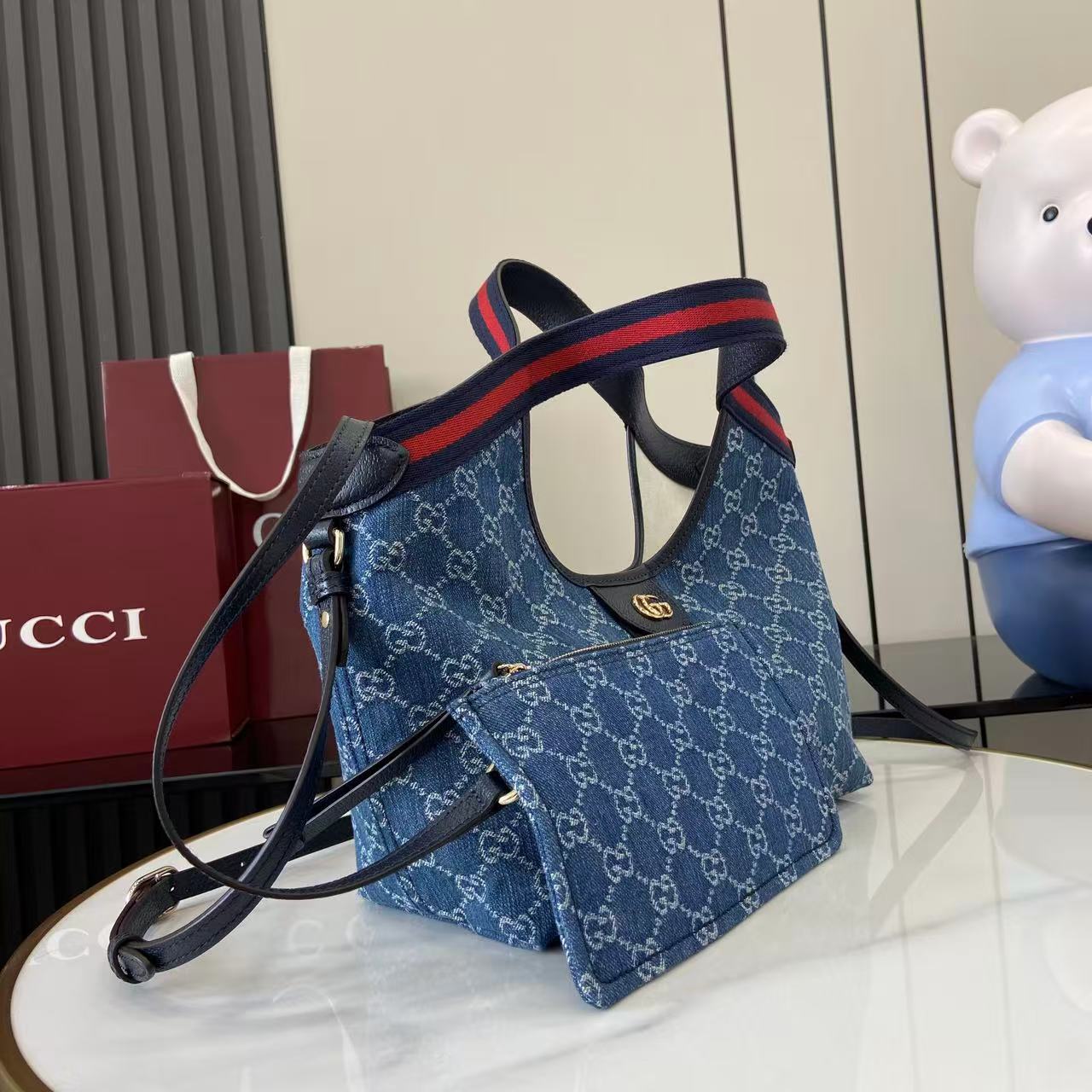 p540。《配全套原厂专柜包装》【新品】Gucci Giglio系列推出小号版本。这款托特包亮相于品牌在佛罗伦萨发布的2026早春时装秀，致敬品牌意大利根源，彰显传承与革新精神。设计以GG丹宁面料匠心打造，饰以织带滚边，配有可拆卸手拿包，更添时尚魅力。
蓝色和白色GG丹宁面料
红蓝织带帆布滚边
浅金色调配件
棕色棉质衬里
双G
可拆卸手拿包
外部：D型环扣
提手（15厘米高）
可拆卸可调节皮革肩带（高度：54厘米 - 63厘米；长度：110厘米 - 129厘米）
隐形磁扣开合
型号：860845。
尺寸：25厘米（宽）x 20厘米（高）x 15厘米（深）
重量：约0.5千克
颜色：蓝皮/牛仔布。
意大利创作