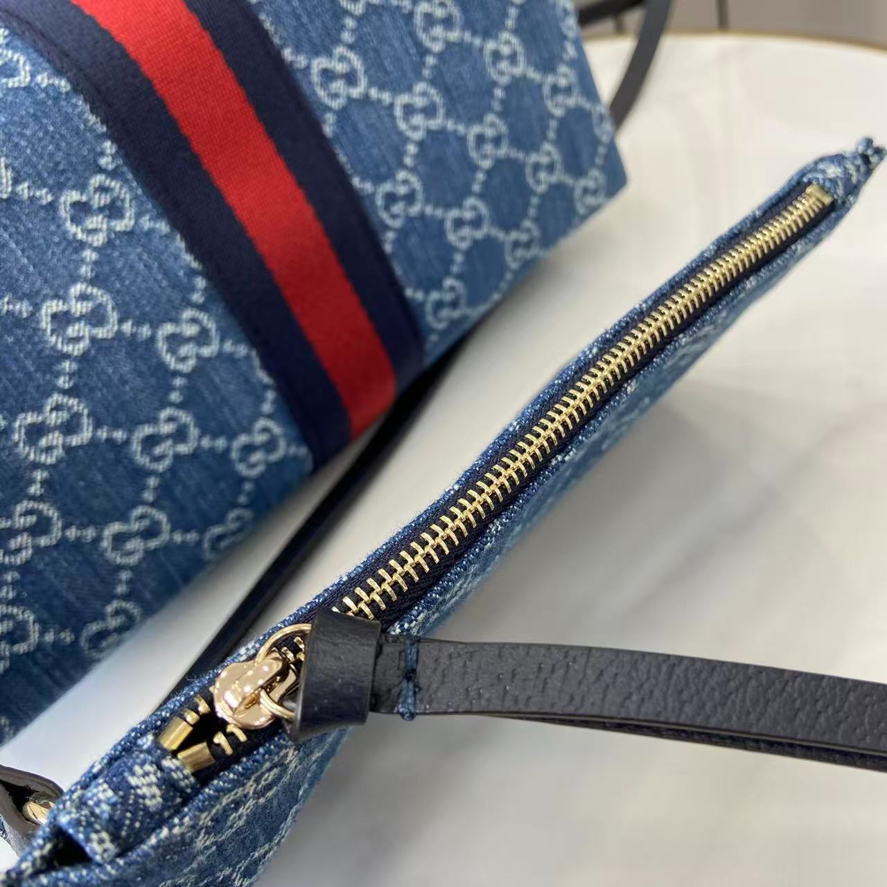 p540。《配全套原厂专柜包装》【新品】Gucci Giglio系列推出小号版本。这款托特包亮相于品牌在佛罗伦萨发布的2026早春时装秀，致敬品牌意大利根源，彰显传承与革新精神。设计以GG丹宁面料匠心打造，饰以织带滚边，配有可拆卸手拿包，更添时尚魅力。
蓝色和白色GG丹宁面料
红蓝织带帆布滚边
浅金色调配件
棕色棉质衬里
双G
可拆卸手拿包
外部：D型环扣
提手（15厘米高）
可拆卸可调节皮革肩带（高度：54厘米 - 63厘米；长度：110厘米 - 129厘米）
隐形磁扣开合
型号：860845。
尺寸：25厘米（宽）x 20厘米（高）x 15厘米（深）
重量：约0.5千克
颜色：蓝皮/牛仔布。
意大利创作