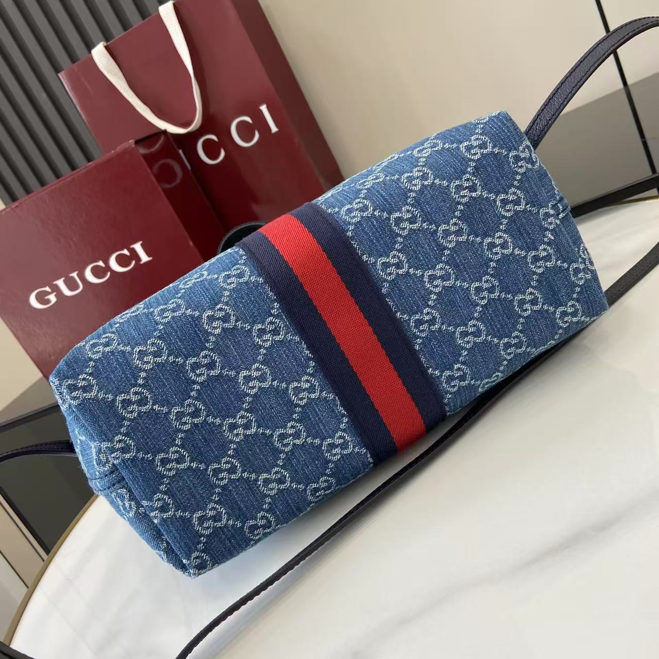 p540。《配全套原厂专柜包装》【新品】Gucci Giglio系列推出小号版本。这款托特包亮相于品牌在佛罗伦萨发布的2026早春时装秀，致敬品牌意大利根源，彰显传承与革新精神。设计以GG丹宁面料匠心打造，饰以织带滚边，配有可拆卸手拿包，更添时尚魅力。
蓝色和白色GG丹宁面料
红蓝织带帆布滚边
浅金色调配件
棕色棉质衬里
双G
可拆卸手拿包
外部：D型环扣
提手（15厘米高）
可拆卸可调节皮革肩带（高度：54厘米 - 63厘米；长度：110厘米 - 129厘米）
隐形磁扣开合
型号：860845。
尺寸：25厘米（宽）x 20厘米（高）x 15厘米（深）
重量：约0.5千克
颜色：蓝皮/牛仔布。
意大利创作