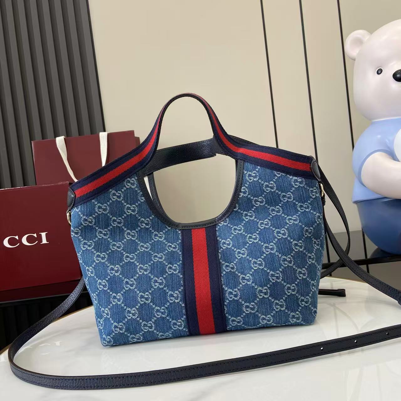p540。《配全套原厂专柜包装》【新品】Gucci Giglio系列推出小号版本。这款托特包亮相于品牌在佛罗伦萨发布的2026早春时装秀，致敬品牌意大利根源，彰显传承与革新精神。设计以GG丹宁面料匠心打造，饰以织带滚边，配有可拆卸手拿包，更添时尚魅力。
蓝色和白色GG丹宁面料
红蓝织带帆布滚边
浅金色调配件
棕色棉质衬里
双G
可拆卸手拿包
外部：D型环扣
提手（15厘米高）
可拆卸可调节皮革肩带（高度：54厘米 - 63厘米；长度：110厘米 - 129厘米）
隐形磁扣开合
型号：860845。
尺寸：25厘米（宽）x 20厘米（高）x 15厘米（深）
重量：约0.5千克
颜色：蓝皮/牛仔布。
意大利创作