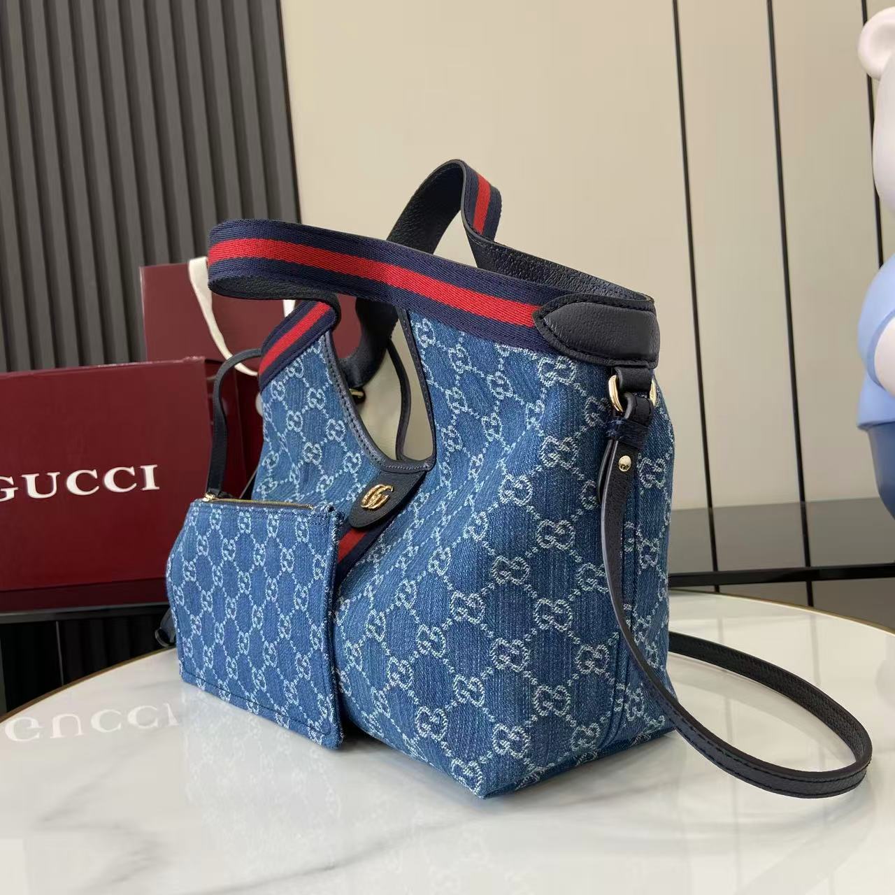 p540。《配全套原厂专柜包装》【新品】Gucci Giglio系列推出小号版本。这款托特包亮相于品牌在佛罗伦萨发布的2026早春时装秀，致敬品牌意大利根源，彰显传承与革新精神。设计以GG丹宁面料匠心打造，饰以织带滚边，配有可拆卸手拿包，更添时尚魅力。
蓝色和白色GG丹宁面料
红蓝织带帆布滚边
浅金色调配件
棕色棉质衬里
双G
可拆卸手拿包
外部：D型环扣
提手（15厘米高）
可拆卸可调节皮革肩带（高度：54厘米 - 63厘米；长度：110厘米 - 129厘米）
隐形磁扣开合
型号：860845。
尺寸：25厘米（宽）x 20厘米（高）x 15厘米（深）
重量：约0.5千克
颜色：蓝皮/牛仔布。
意大利创作