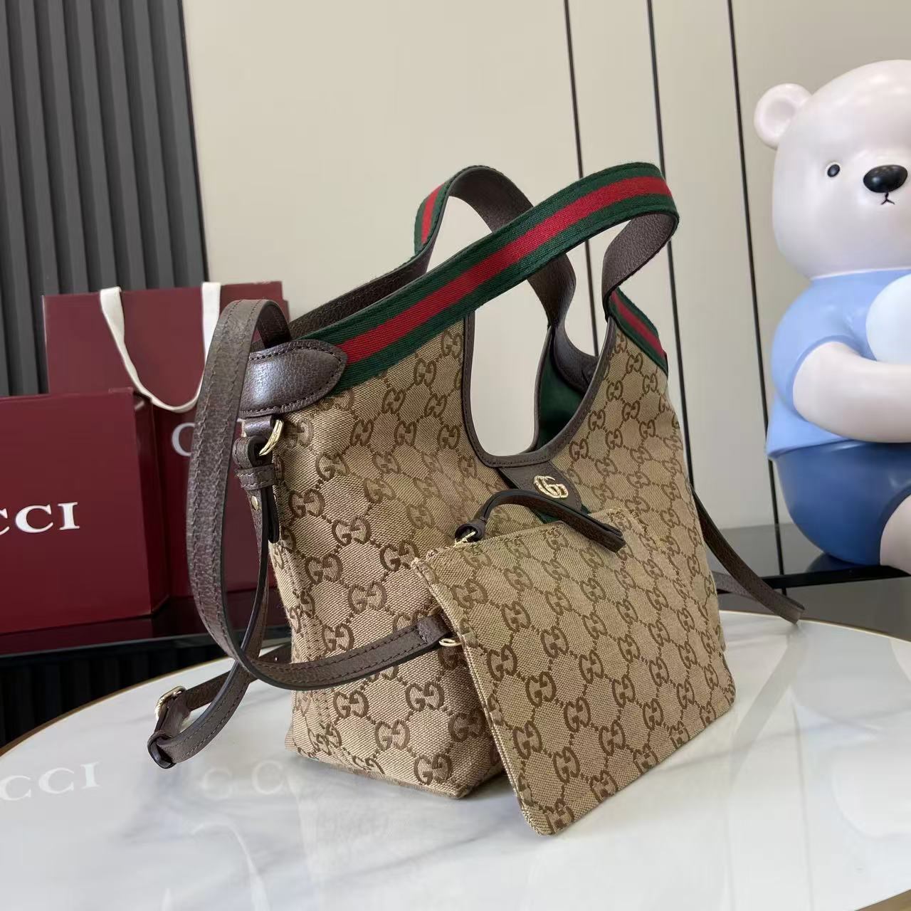 p540。《配全套原厂专柜包装》【新品】Gucci Giglio系列推出小号版本。这款托特包亮相于品牌在佛罗伦萨发布的2026早春时装秀，致敬品牌意大利根源，彰显传承与革新精神。空间宽敞的设计以GG帆布面料匠心打造，饰以织带滚边，配有可拆卸手拿包，更添时尚魅力。
米色和深棕色GG帆布
红绿织带帆布滚边
浅金色调配件
绿色亚麻棉混纺衬里
双G
可拆卸手拿包
外部：D型环扣
提手（15厘米高）
可拆卸可调节皮革肩带（高度：54厘米 - 63厘米；长度：110厘米 - 129厘米）
隐形磁扣开合
型号：860845。
尺寸25厘米（宽）x 20厘米（高）x 15厘米（深）
重量：约0.5千克
颜色：棕色/杏布。
意大利创作