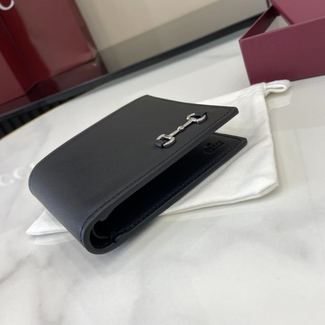 p180。《配全套原厂专柜包装》2025秋冬系列选用马衔扣图案装点甄选小皮件，成就品牌美学设计。这款双折钱包以牛皮革匠心打造，经典元素点缀其上。
黑色光面牛皮革
钯金色调配件
马衔扣
内部：八个卡片隔层，两个钞票隔层
型号：846950。
闭合时尺寸：11厘米（宽）x 9厘米（高）；
打开时尺寸：21厘米（宽）x 9厘米（高）
颜色：黑皮。
意大利创作