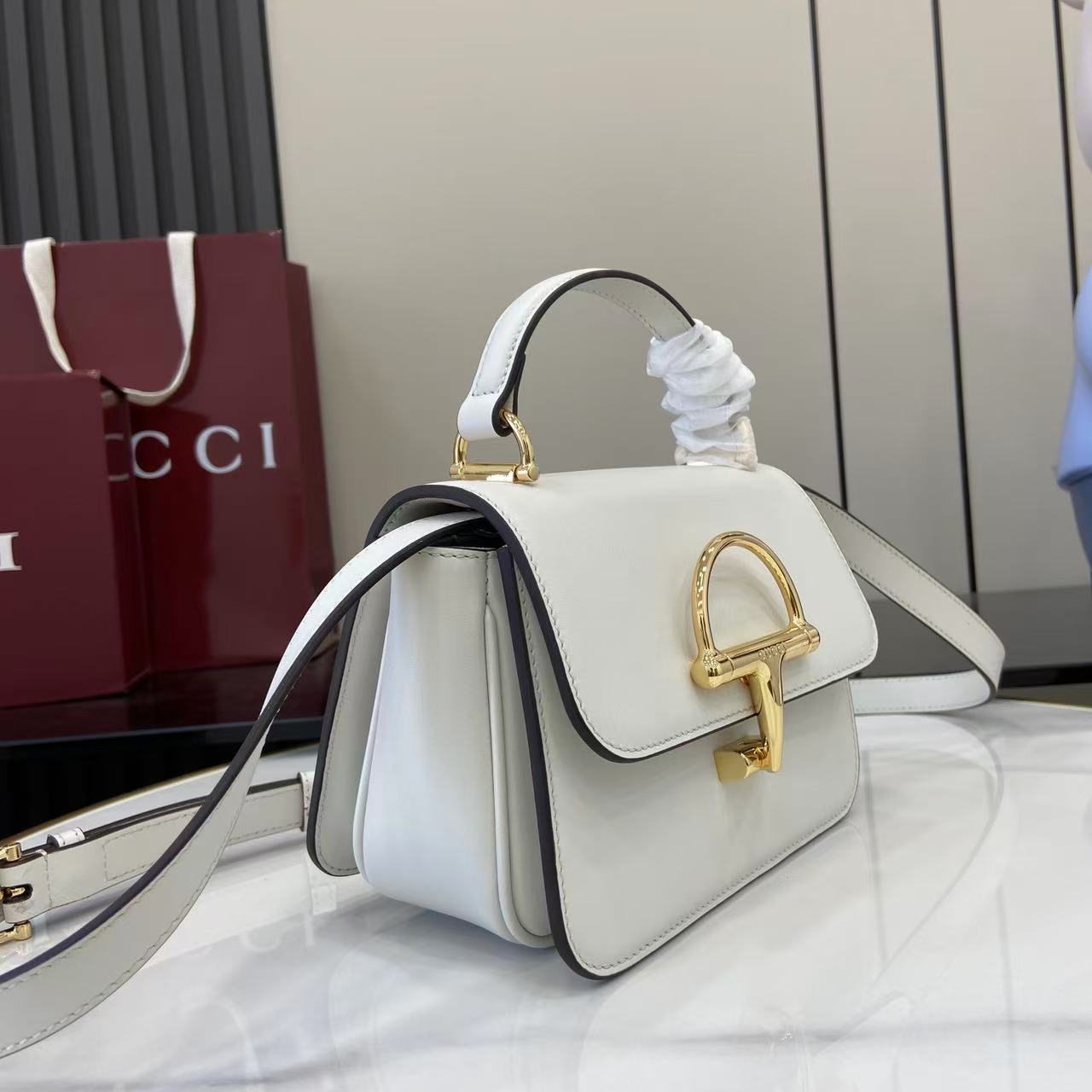 p750。《配全套原厂专柜包装》Gucci Siena系列焕新演绎品牌经典马衔扣元素，打造魅力手袋单品。这款手提包选用精细光面皮革匠心打造，挺括造型融蕴源自20世纪70年代的半马衔扣搭扣设计细节
白色光面皮革
金色调配件
白色皮革衬里
内部：3层接档，1个开口口袋
提手（6.5厘米高）
可拆卸可调节皮革肩带（高度：45厘米；长度：43厘米 - 47厘米）
半马衔扣造型按扣
型号：855536。
尺寸：19厘米（宽）x 13厘米（高）x 8.5厘米（深）
重量：约0.5千克
颜色：白色全皮。