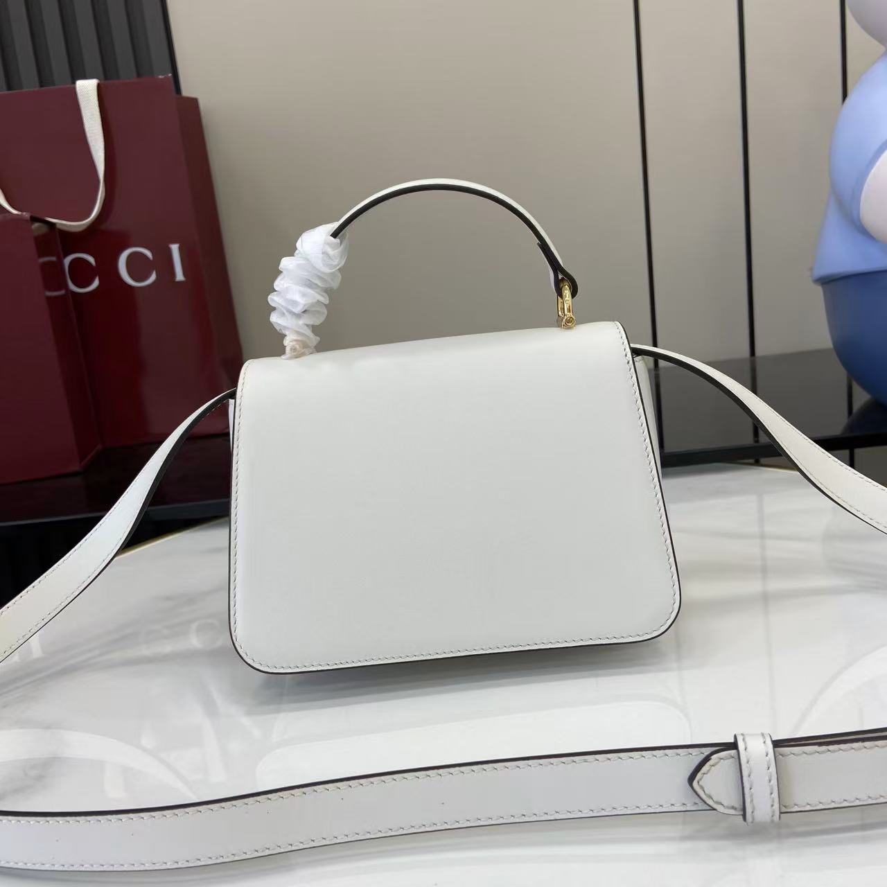 p750。《配全套原厂专柜包装》Gucci Siena系列焕新演绎品牌经典马衔扣元素，打造魅力手袋单品。这款手提包选用精细光面皮革匠心打造，挺括造型融蕴源自20世纪70年代的半马衔扣搭扣设计细节
白色光面皮革
金色调配件
白色皮革衬里
内部：3层接档，1个开口口袋
提手（6.5厘米高）
可拆卸可调节皮革肩带（高度：45厘米；长度：43厘米 - 47厘米）
半马衔扣造型按扣
型号：855536。
尺寸：19厘米（宽）x 13厘米（高）x 8.5厘米（深）
重量：约0.5千克
颜色：白色全皮。