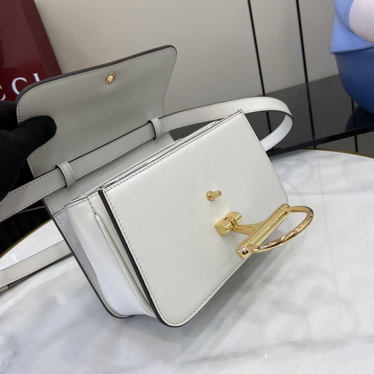 p750。《配全套原厂专柜包装》Gucci Siena系列焕新演绎品牌经典马衔扣元素，打造魅力手袋单品。这款手提包选用精细光面皮革匠心打造，挺括造型融蕴源自20世纪70年代的半马衔扣搭扣设计细节
白色光面皮革
金色调配件
白色皮革衬里
内部：3层接档，1个开口口袋
提手（6.5厘米高）
可拆卸可调节皮革肩带（高度：45厘米；长度：43厘米 - 47厘米）
半马衔扣造型按扣
型号：855536。
尺寸：19厘米（宽）x 13厘米（高）x 8.5厘米（深）
重量：约0.5千克
颜色：白色全皮。