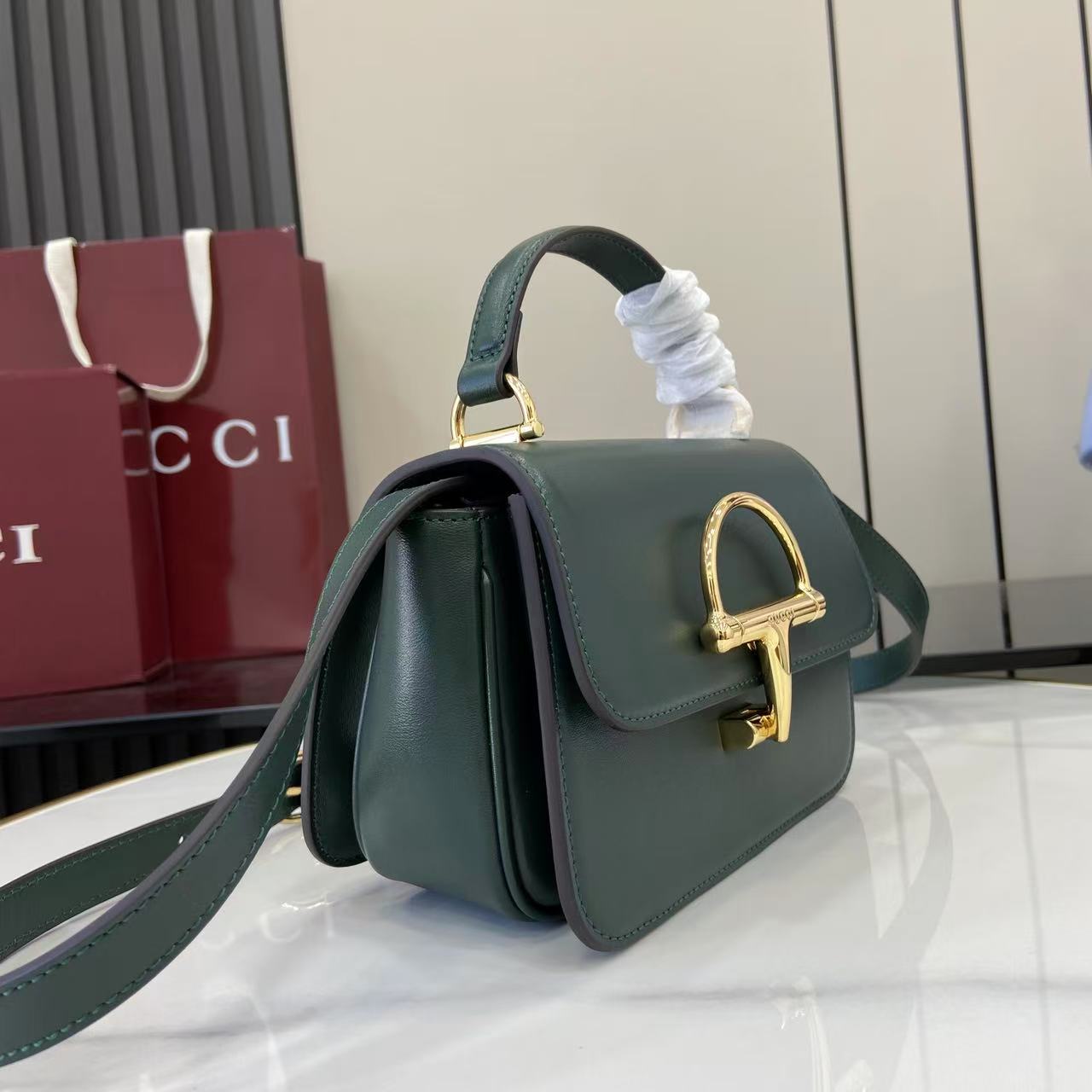 p750。《配全套原厂专柜包装》Gucci Siena系列焕新演绎品牌经典马衔扣元素，打造魅力手袋单品。这款手提包选用精细光面皮革匠心打造，挺括造型融蕴源自20世纪70年代的半马衔扣搭扣设计细节
绿色光面皮革
金色调配件
绿色皮革衬里
内部：3层接档，1个开口口袋
提手（6.5厘米高）
可拆卸可调节皮革肩带（高度：45厘米；长度：43厘米 - 47厘米）
半马衔扣造型按扣
型号：855536。
尺寸：19厘米（宽）x 13厘米（高）x 8.5厘米（深）
重量：约0.5千克
颜色：绿色全皮。