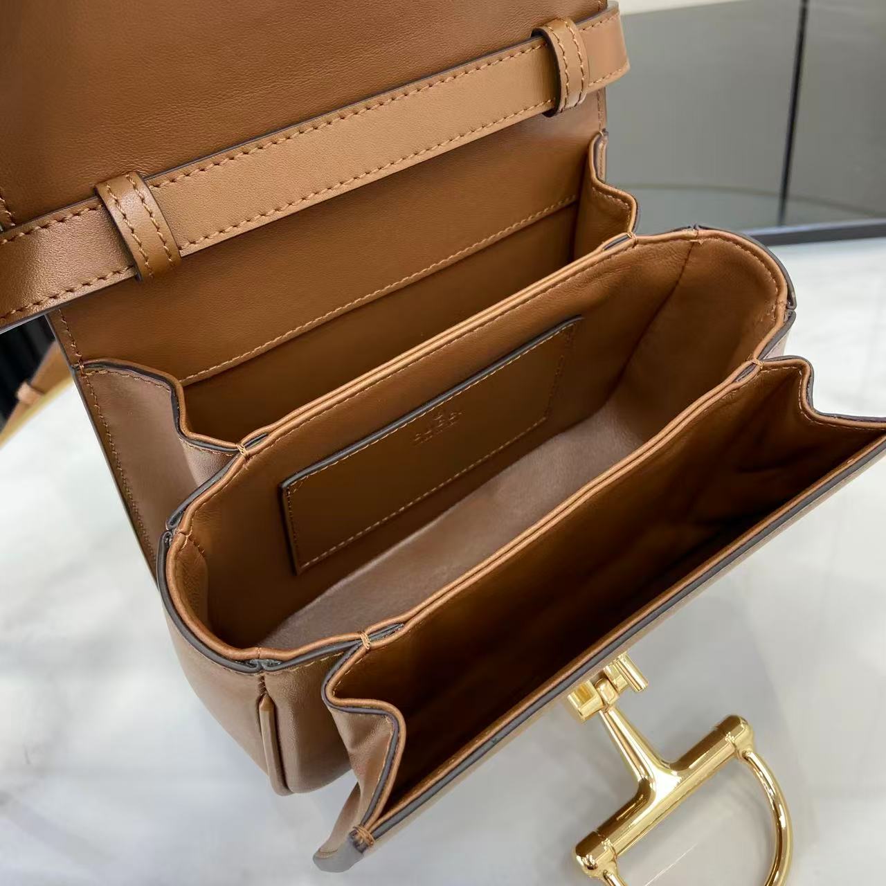 p750。《配全套原厂专柜包装》Gucci Siena系列焕新演绎品牌经典马衔扣元素，打造魅力手袋单品。这款手提包选用精细光面皮革匠心打造，挺括造型融蕴源自20世纪70年代的半马衔扣搭扣设计细节
棕色光面皮革
金色调配件
棕色皮革衬里
内部：3层接档，1个开口口袋
提手（6.5厘米高）
可拆卸可调节皮革肩带（高度：45厘米；长度：43厘米 - 47厘米）
半马衔扣造型按扣
型号：855536。
尺寸：19厘米（宽）x 13厘米（高）x 8.5厘米（深）
重量：约0.5千克
颜色：棕色全皮。