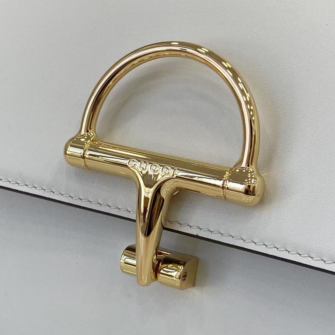 p810。《配全套原厂专柜包装》Gucci Siena系列焕新演绎品牌经典马衔扣元素，打造魅力手袋单品。这款手提包选用精细光面皮革匠心打造，挺括造型融蕴源自20世纪70年代的半马衔扣搭扣设计细节
白色光面皮革
金色调配件
白色皮革衬里
内部：3层接档，1个拉链口袋
提手（8厘米高）
可拆卸可调节皮革肩带（高度：46厘米 - 52厘米；长度：142厘米）
半马衔扣造型按扣
型号：855535。
尺寸：25.5厘米（宽）x 16厘米（高）x 9厘米（深）
重量：约0.75千克
颜色：白色全皮。