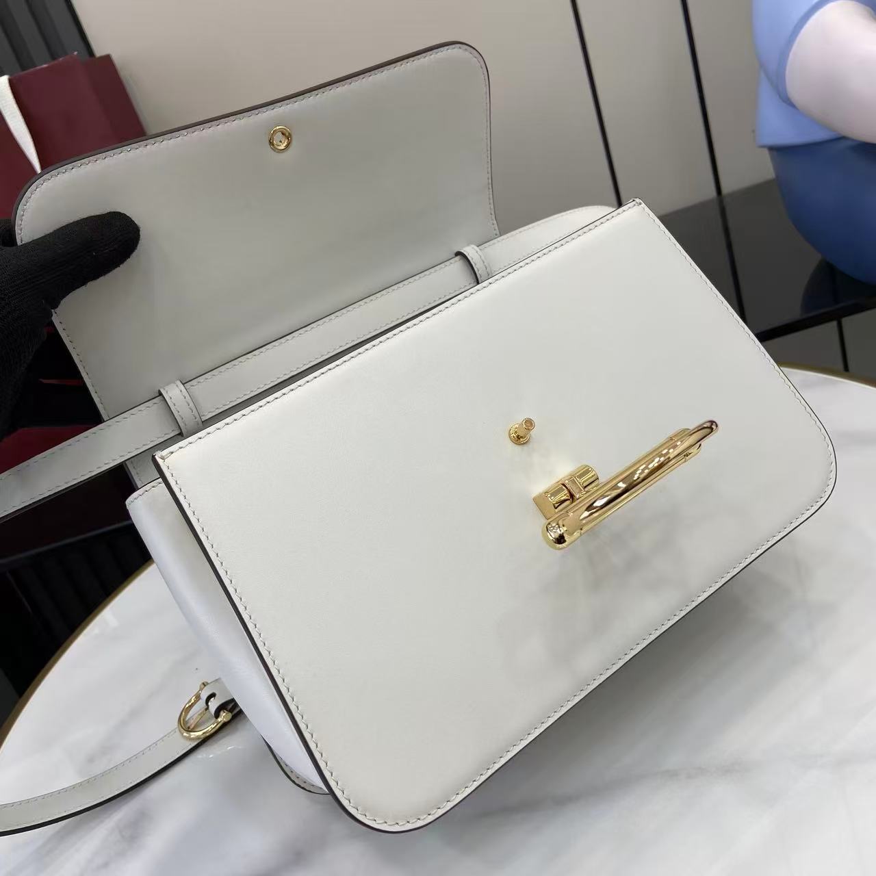 p810。《配全套原厂专柜包装》Gucci Siena系列焕新演绎品牌经典马衔扣元素，打造魅力手袋单品。这款手提包选用精细光面皮革匠心打造，挺括造型融蕴源自20世纪70年代的半马衔扣搭扣设计细节
白色光面皮革
金色调配件
白色皮革衬里
内部：3层接档，1个拉链口袋
提手（8厘米高）
可拆卸可调节皮革肩带（高度：46厘米 - 52厘米；长度：142厘米）
半马衔扣造型按扣
型号：855535。
尺寸：25.5厘米（宽）x 16厘米（高）x 9厘米（深）
重量：约0.75千克
颜色：白色全皮。