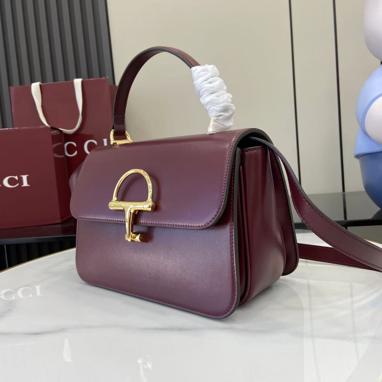 p810。《配全套原厂专柜包装》Gucci Siena系列焕新演绎品牌经典马衔扣元素，打造魅力手袋单品。这款手提包选用精细光面皮革匠心打造，挺括造型融蕴源自20世纪70年代的半马衔扣搭扣设计细节
安可拉红色光面皮革
金色调配件
安可拉红色皮革衬里
内部：3层接档，1个拉链口袋
提手（8厘米高）
可拆卸可调节皮革肩带（高度：46厘米 - 52厘米；长度：142厘米）
半马衔扣造型按扣
型号：855535。
尺寸：25.5厘米（宽）x 16厘米（高）x 9厘米（深）
重量：约0.75千克
颜色：安可拉红色全皮。