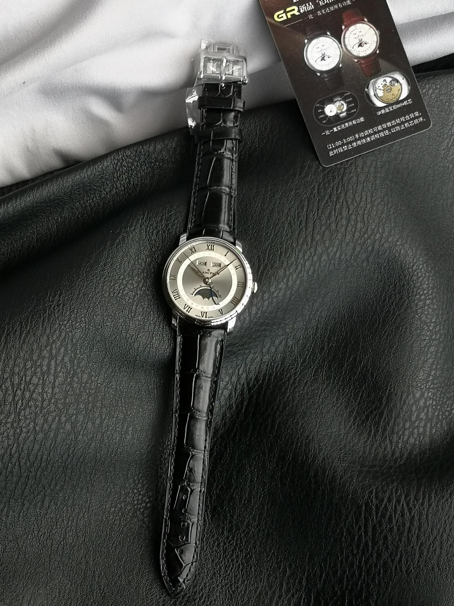 NO:947085,GR Factory's new Blancpain Classic Series 6654 Full Calendar Moon Phase Watch 1. Stepped case, simple yet three-dimensional, 40mm diameter. 2. Elegant dial with clear and easy-to-read concentric circle layout, three-dimensional Roman hour markers on the outside, and calendar indication in the inner circle; 3. Hollow leaf hand, large logo second hand, and blue steel calendar hand. Each of the three performs their own duties. The 11 o'clock and 1 o'clock windows display the day of the week and the month.  Equipped with the 6654.5 self-winding movement, the power reserve is up to 72 hours. The four-way hidden adjustment buttons are cleverly integrated into the watch lugs, taking into account both convenient operation and aesthetic balance. Blancpain’s moon phase face was once talked about by watch friends. The playful little face has the same purpose as the emoji expression. It is not only a tool to record time, but also an art treasure on the wrist, highlighting the noble temperament of the wearer. It can become the focus in both business and leisure occasions.19860909GR Factory新品宝珀经典系列6654全历月相腕表 1阶梯式表壳,简约中有立体感,表径40mm 2素雅表盘,同心圆布局清晰易读,外围罗马字立体时标,内圆日历指示； 3镂空柳叶针、logo大秒针、蓝钢日历针,三者各司其职,11点位与1点位窗口,显示星期与月份. 搭载6654.5自动上链机芯,动力储存长达72小时,四方位隐藏式调校按钮巧妙融入表耳,兼顾便捷操作与美学平衡,宝珀的月相脸一度被表友们津津乐道,俏皮小脸与emoji表情有异曲同工之妙. 它不仅是记录时间的工具,更是腕间的艺术珍品,彰显佩戴者的尊贵气质,无论商务还是休闲场合,都能成为焦点,,Watch