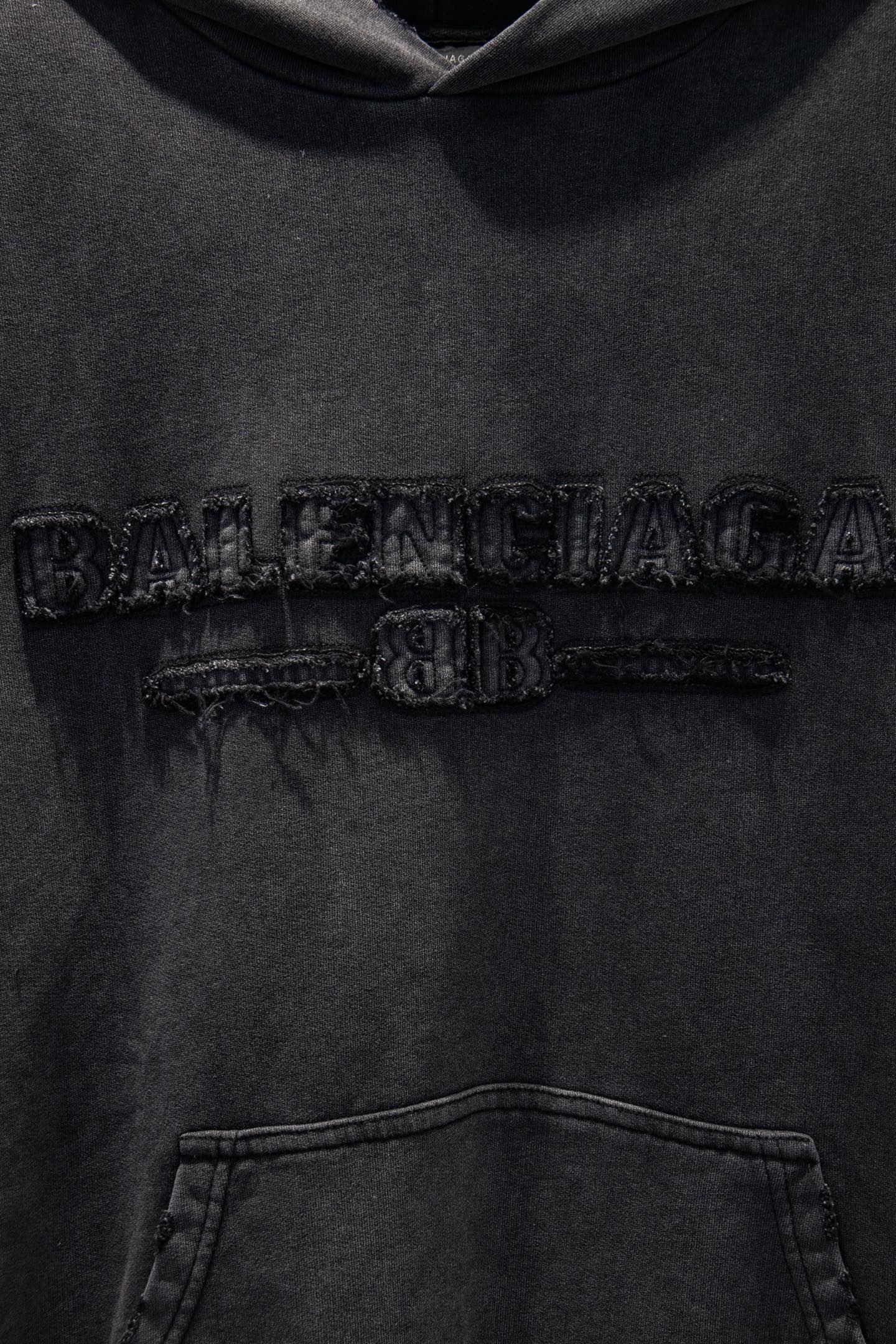 同图不同版，冲🐮货，随意对比 款号：5231#💰254
🆕Balenciaga 做旧新款刺绣连帽卫衣

os版型真的很迷人 
巴黎世家也真的是绝绝子
每一季新品版型都做到极致
实穿度很高，随意搭都nice✔️
-
⚠️100%棉
采用订色订染毛圈纯棉卫衣面，420g双股双纱，手感舒适 进口针织针梳棉进行制作，厚度适中，有垂感又有轮廓型，上身就是一个舒适！！对微胖身型包容性强，穿上瞬间瘦五斤！

前幅#后幅刺绣元素# 艺术排列英文字母 进口田岛高密度重工刺绣工艺  字体立体饱满

衣身加入做旧水洗破洞元素处理，更大大增加了服装的趣味性；独特的视觉效果。

下摆 宽松收口 双层面料 收口效果好  精致锁边 

颜色: 水洗黑 尺码:XS-S-M-L