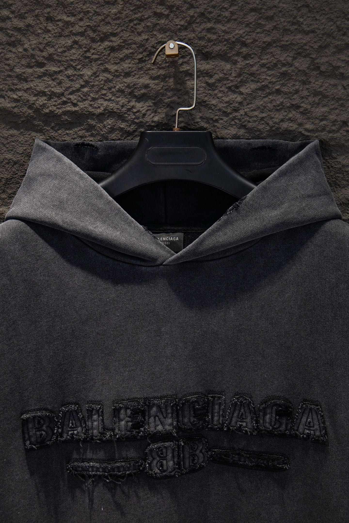 同图不同版，冲🐮货，随意对比 款号：5231#💰254
🆕Balenciaga 做旧新款刺绣连帽卫衣

os版型真的很迷人 
巴黎世家也真的是绝绝子
每一季新品版型都做到极致
实穿度很高，随意搭都nice✔️
-
⚠️100%棉
采用订色订染毛圈纯棉卫衣面，420g双股双纱，手感舒适 进口针织针梳棉进行制作，厚度适中，有垂感又有轮廓型，上身就是一个舒适！！对微胖身型包容性强，穿上瞬间瘦五斤！

前幅#后幅刺绣元素# 艺术排列英文字母 进口田岛高密度重工刺绣工艺  字体立体饱满

衣身加入做旧水洗破洞元素处理，更大大增加了服装的趣味性；独特的视觉效果。

下摆 宽松收口 双层面料 收口效果好  精致锁边 

颜色: 水洗黑 尺码:XS-S-M-L