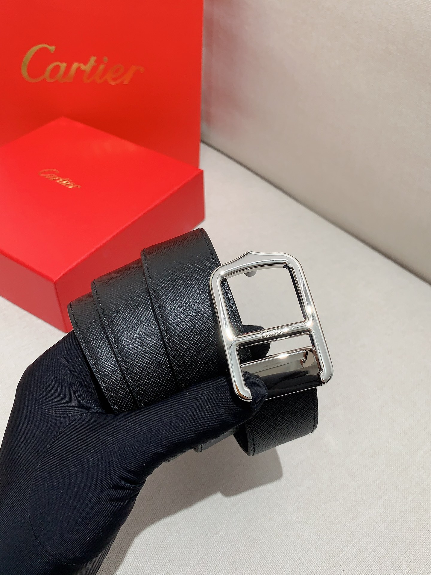  卡地亚针扣式皮带，Cartier标志。黑色与棕色牛皮双面皮带，浮雕“Cartier”标志。尺寸：宽35