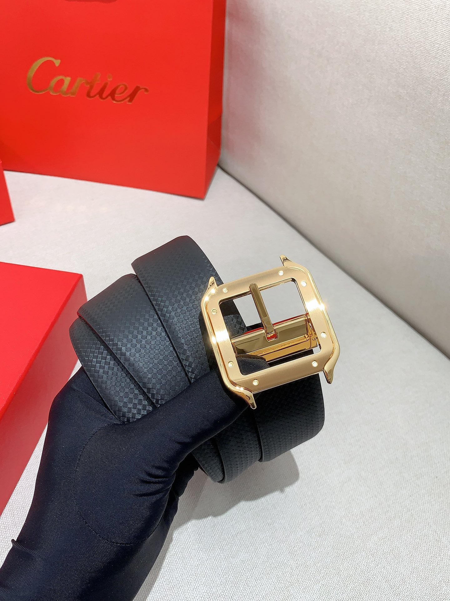  卡地亚针扣式皮带，Cartier标志。黑色与棕色牛皮双面皮带，浮雕“Cartier”标志。尺寸：宽35