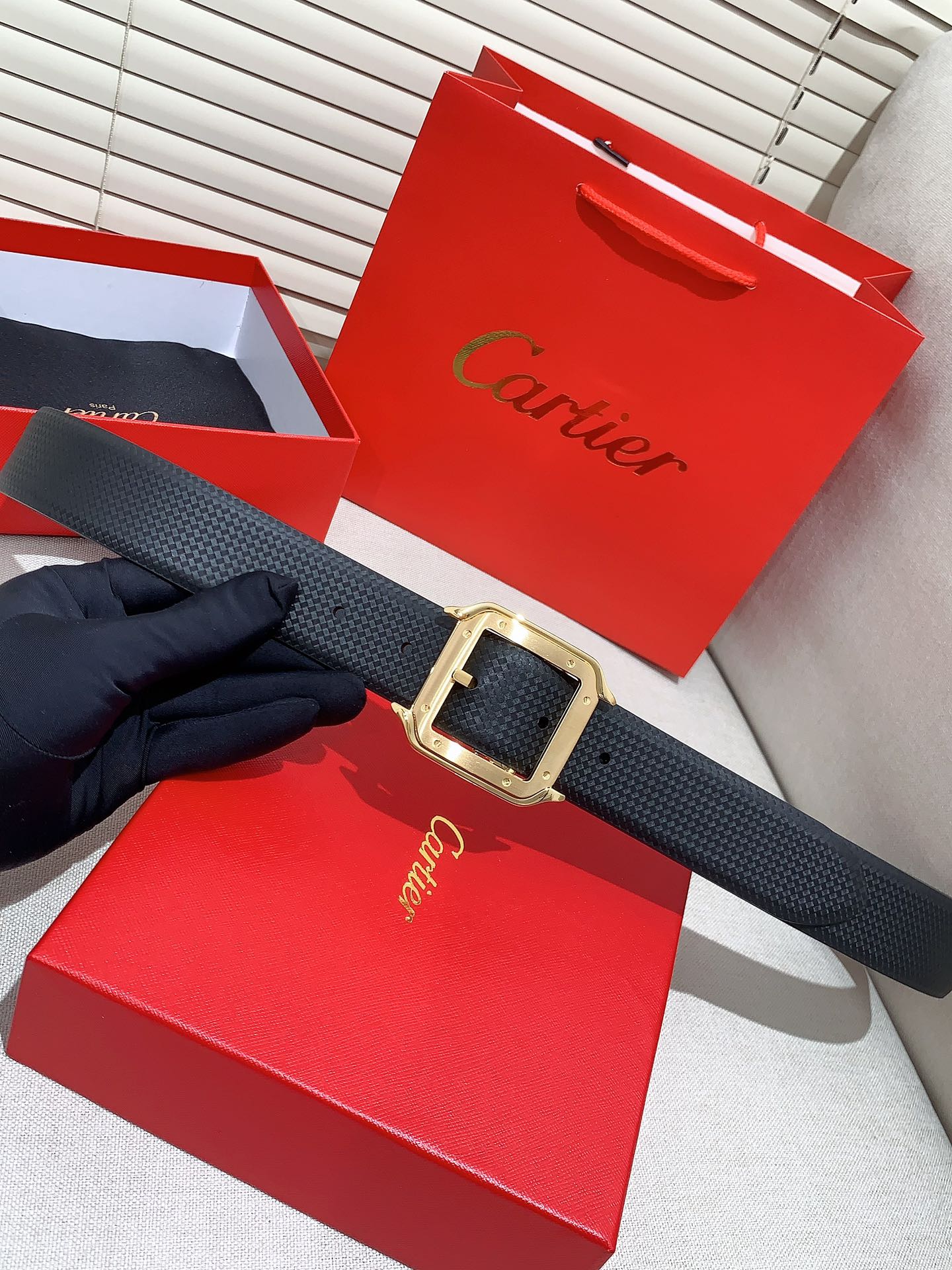  卡地亚针扣式皮带，Cartier标志。黑色与棕色牛皮双面皮带，浮雕“Cartier”标志。尺寸：宽35