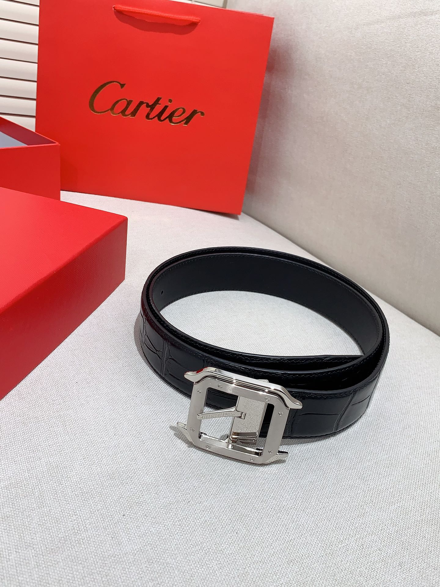  卡地亚针扣式皮带，Cartier标志。黑色与棕色牛皮双面皮带，浮雕“Cartier”标志。尺寸：宽35