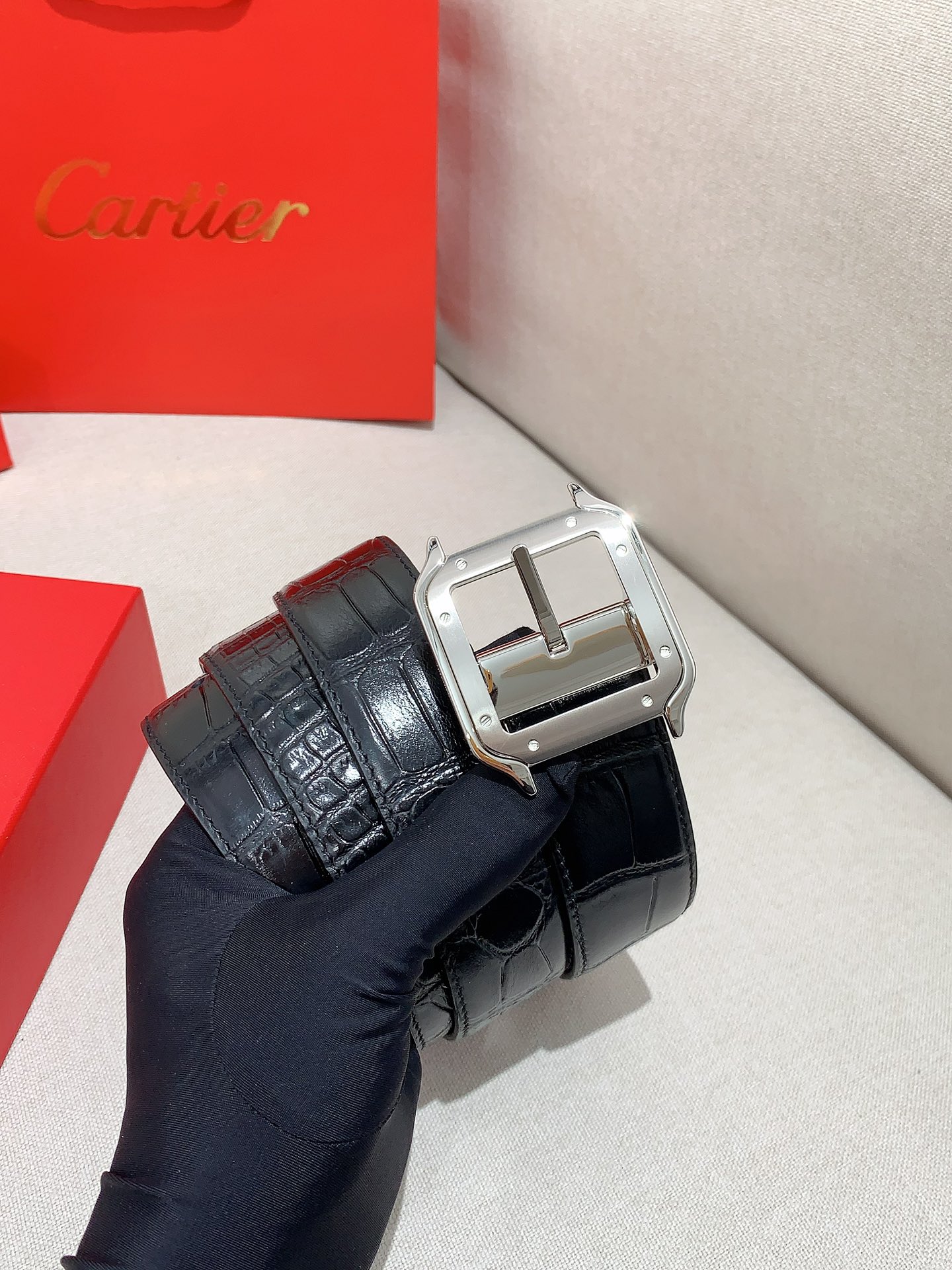  卡地亚针扣式皮带，Cartier标志。黑色与棕色牛皮双面皮带，浮雕“Cartier”标志。尺寸：宽35