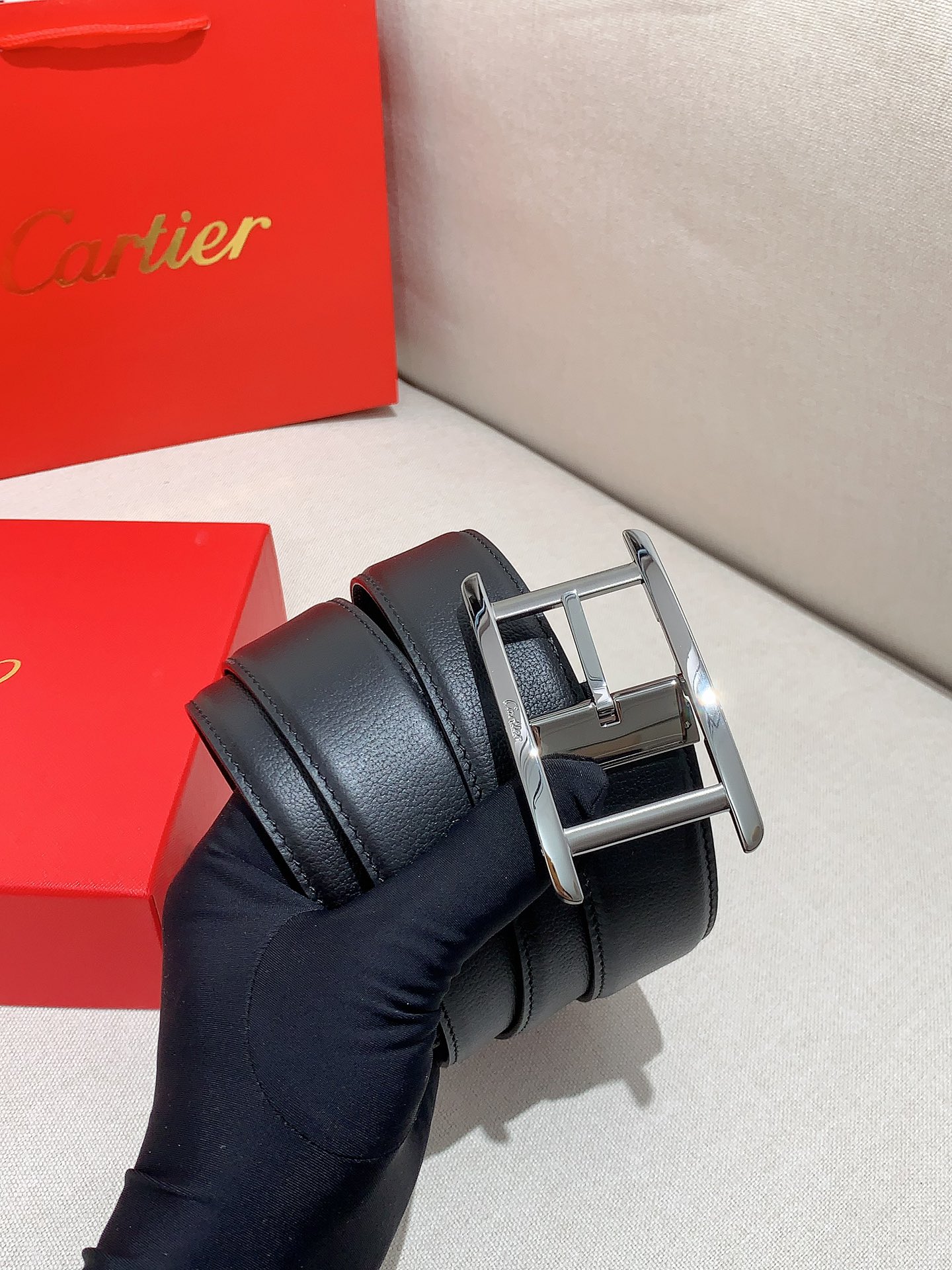  卡地亚针扣式皮带，Cartier标志。黑色与棕色牛皮双面皮带，浮雕“Cartier”标志。尺寸：宽35