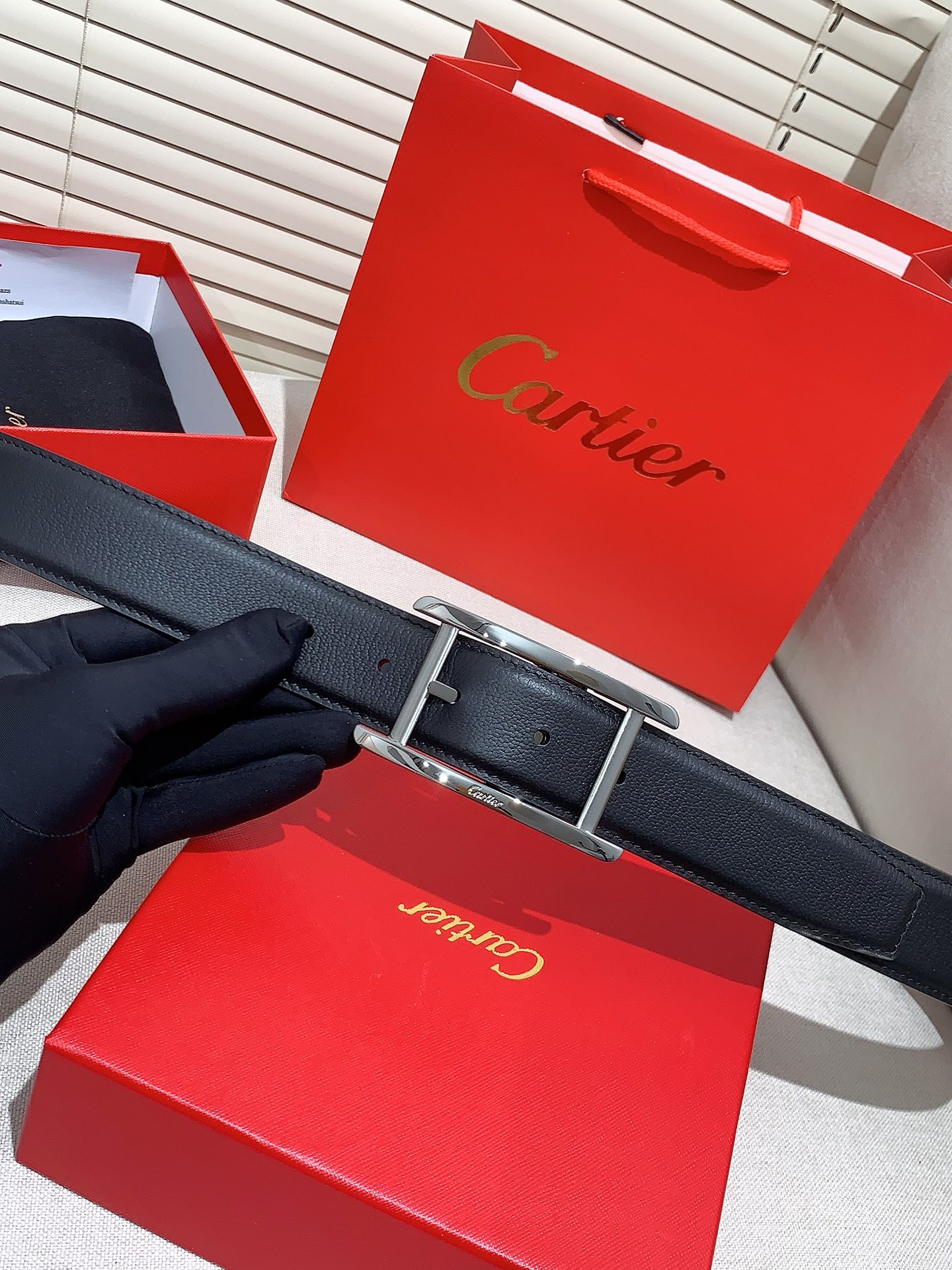  卡地亚针扣式皮带，Cartier标志。黑色与棕色牛皮双面皮带，浮雕“Cartier”标志。尺寸：宽35