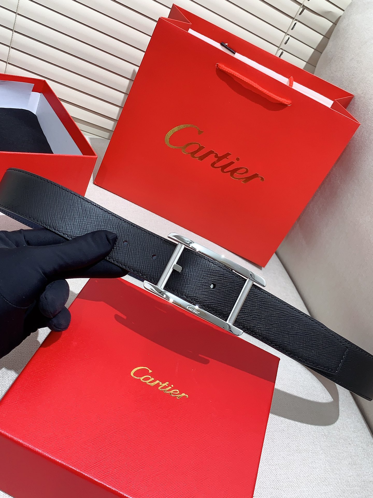  卡地亚针扣式皮带，Cartier标志。黑色与棕色牛皮双面皮带，浮雕“Cartier”标志。尺寸：宽35