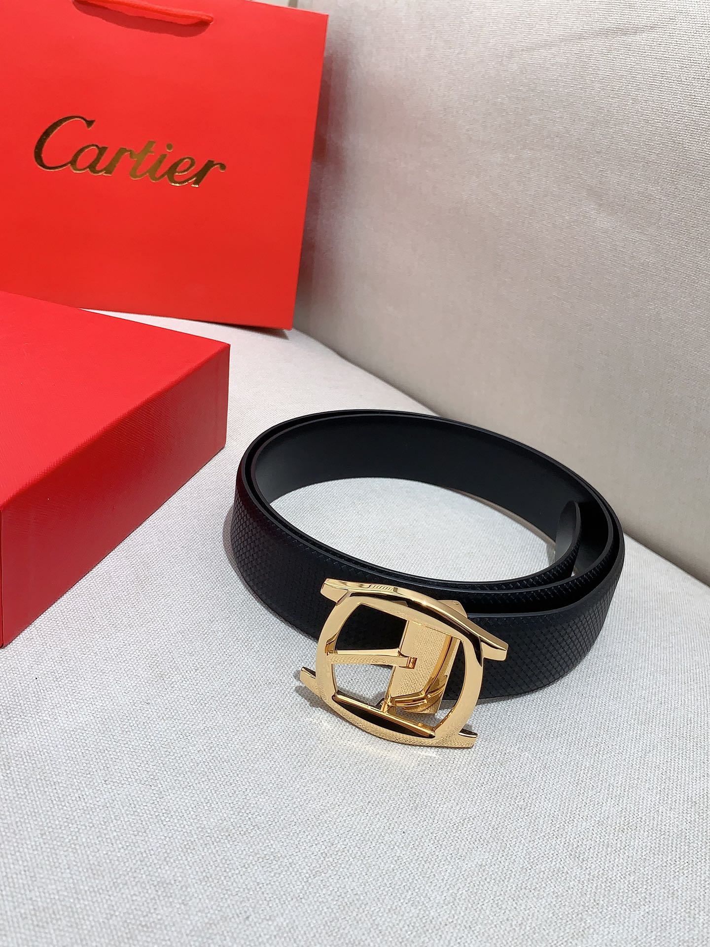  卡地亚针扣式皮带，Cartier标志。黑色与棕色牛皮双面皮带，浮雕“Cartier”标志。尺寸：宽35