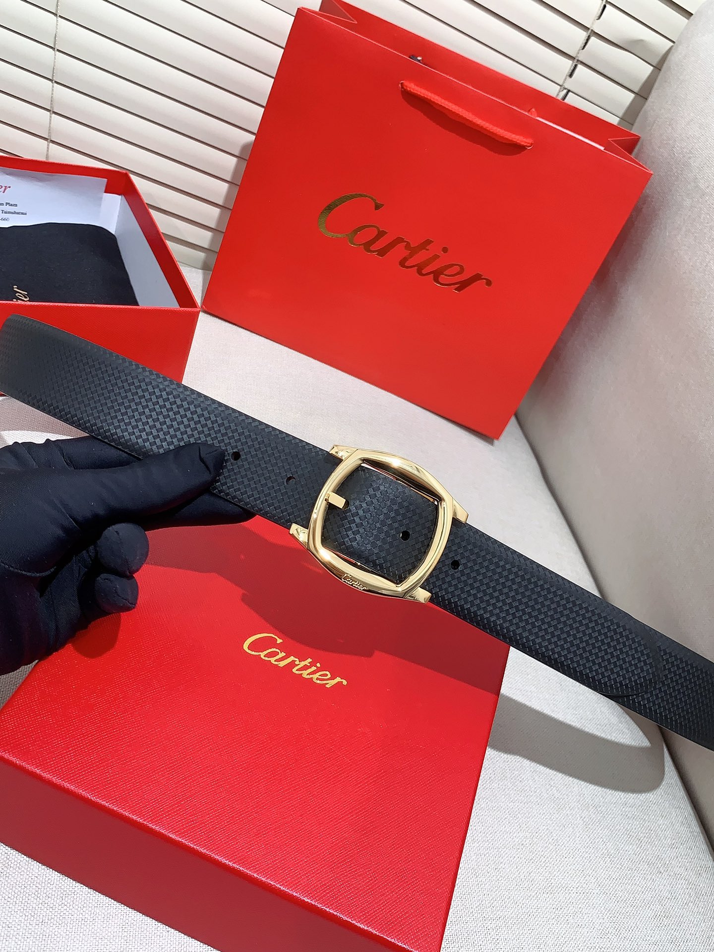  卡地亚针扣式皮带，Cartier标志。黑色与棕色牛皮双面皮带，浮雕“Cartier”标志。尺寸：宽35