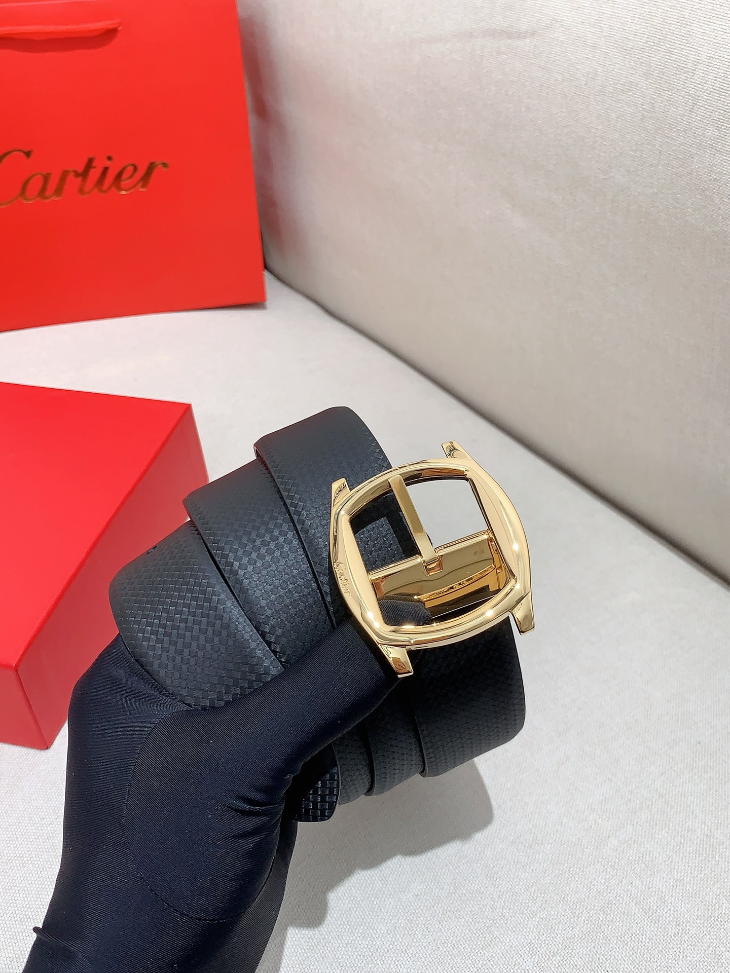  卡地亚针扣式皮带，Cartier标志。黑色与棕色牛皮双面皮带，浮雕“Cartier”标志。尺寸：宽35