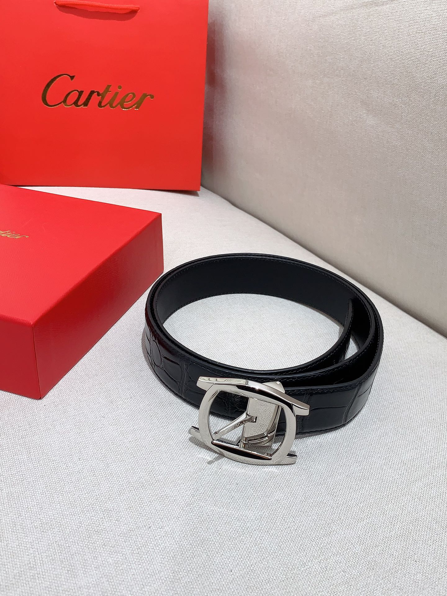  卡地亚针扣式皮带，Cartier标志。黑色与棕色牛皮双面皮带，浮雕“Cartier”标志。尺寸：宽35