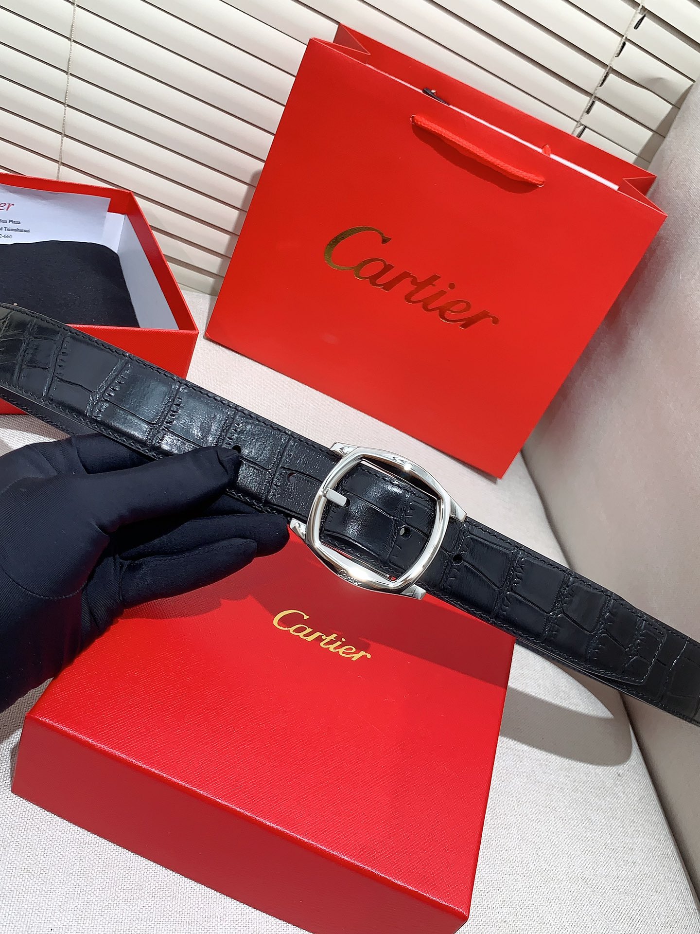  卡地亚针扣式皮带，Cartier标志。黑色与棕色牛皮双面皮带，浮雕“Cartier”标志。尺寸：宽35