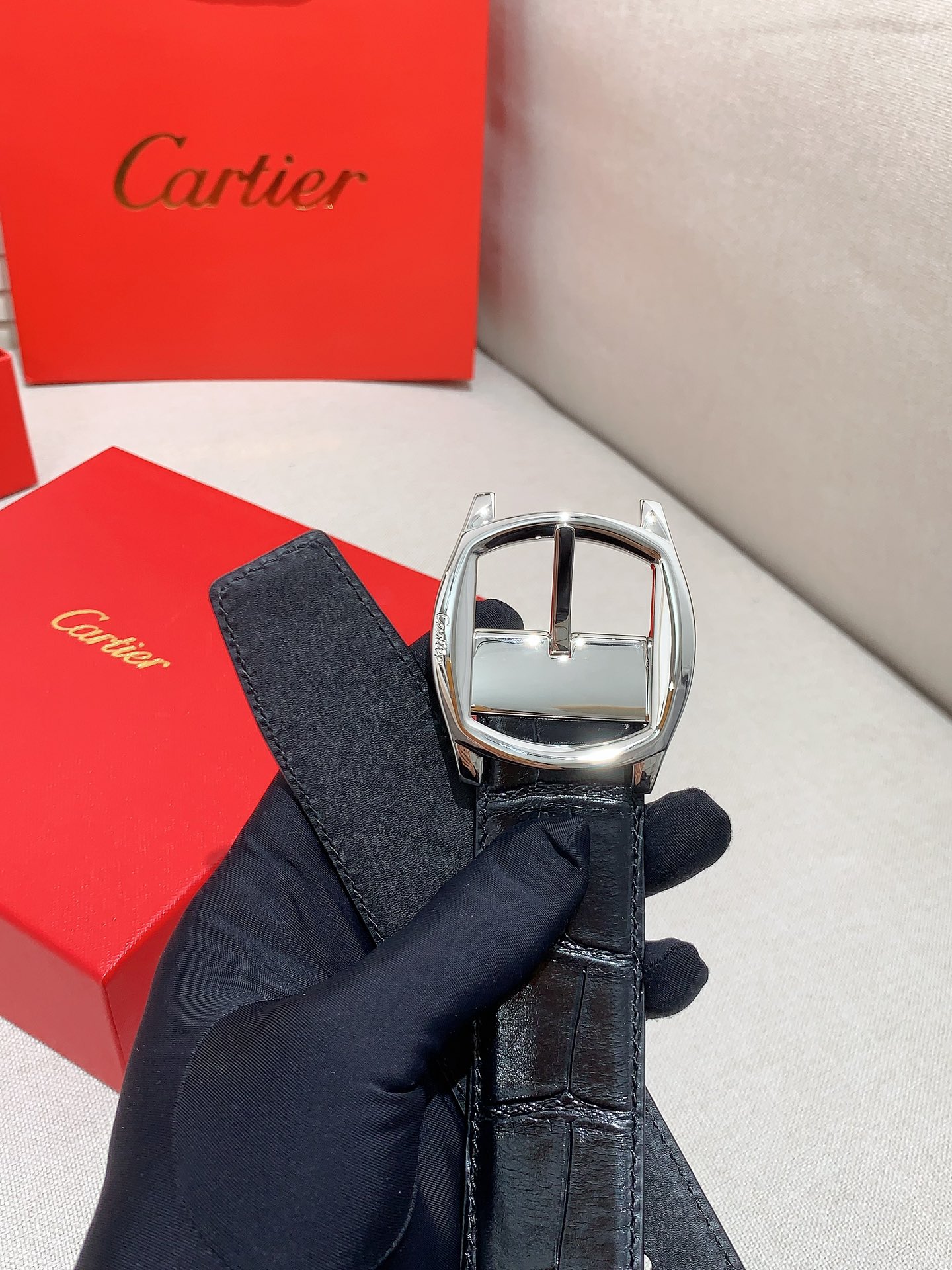  卡地亚针扣式皮带，Cartier标志。黑色与棕色牛皮双面皮带，浮雕“Cartier”标志。尺寸：宽35