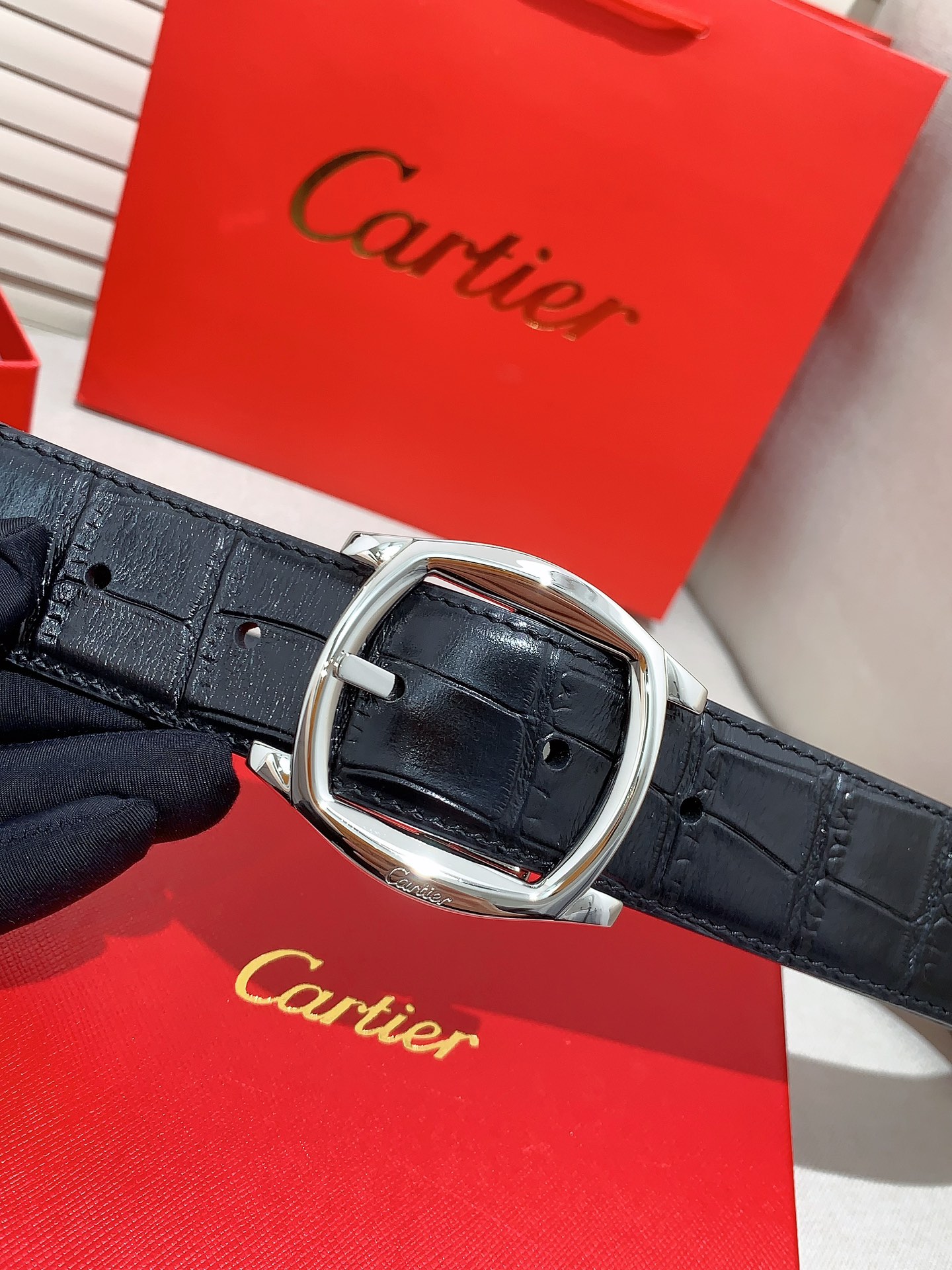  卡地亚针扣式皮带，Cartier标志。黑色与棕色牛皮双面皮带，浮雕“Cartier”标志。尺寸：宽35