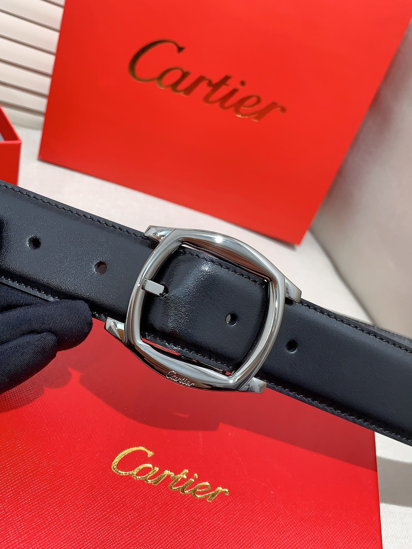  卡地亚针扣式皮带，Cartier标志。黑色与棕色牛皮双面皮带，浮雕“Cartier”标志。尺寸：宽35