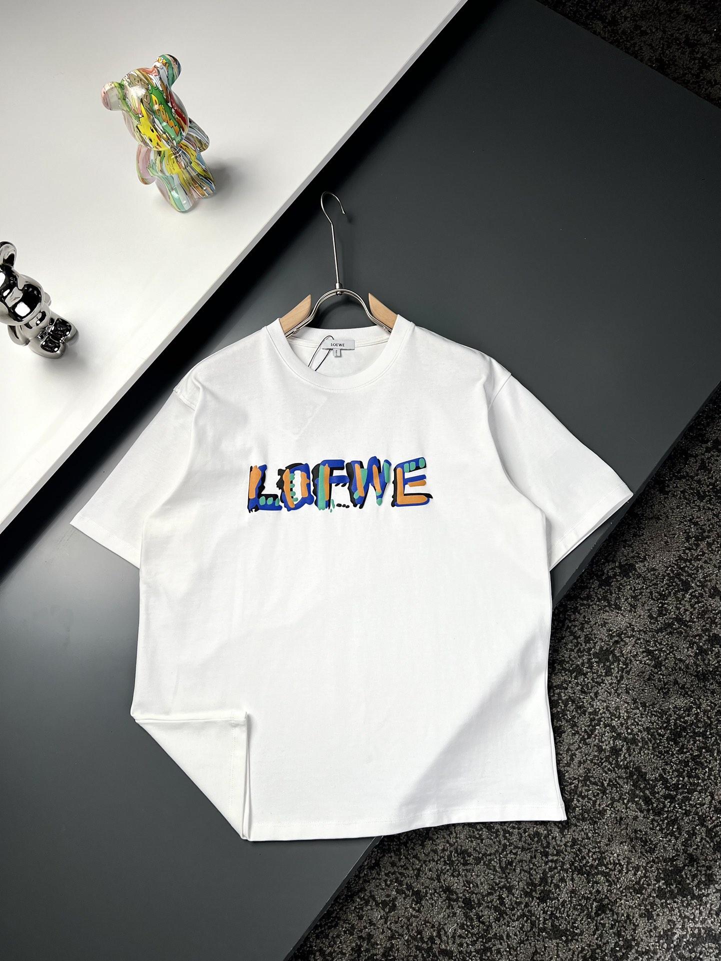 NO:125327,Loewe* Loewe's long shoulders, wide bust, sleeves, S7153.55924 M73556125 L7556.56326 XL77586527 Recommended size S/100-120M/ 120-150L/150-170XL/ 170-200 Foam color-blocking graffiti letters short-sleeved T-shirt *Use super high cost 380g high gram heavy double strand double yarn pure cotton fabric This fabric is thick and crisp, warm and comfortable to wear, ready-to-wear, those who like high-end versions can choose the first choice Three-dimensional OS tailoring style, waste, but the upper body is very casual and full of pulling down *Furn foam printing  Add a certain proportion of high-expansion coefficient chemicals to the glue printing dye, and bubble after high temperature steam to achieve a three-dimensional effect. Colorful foaming printing takes time and effort to add colors layer by layer on the original foaming process, so as to achieve a bright three-dimensional and graffiti-like back design of the back turtle back to make the neckline smoother and not easy to deform. The back small towel embroidered logo pattern *The main recommendation model is a very ingenious basic model. Simple and fashionable style reveals the same style as men and women. Model number JMM8809 White Black S-Xl,,loewe,loewe,T-shirt,tees,t-shirt,alexander wang19860909Loewe*罗意威 衣长肩宽胸围袖长 S7153.55924 M73556125 L7556.56326 XL77586527 推荐尺寸 S/100-120M/ 120-150L/150-170XL/ 170-200 发泡拼色涂鸦字母短袖T恤 *采用超级高成本的380克高克重双股双纱纯棉面料 此面料厚实挺括 穿着既保暖又舒适 成衣普洗 喜欢高版本的可以首选 立体OS剪裁版型 废料 但上身非常有休闲拉垮感满满 *前幅发泡印花 在胶浆印花染料中加入一定比例的高膨胀系数的化学物质,经高温汽蒸后起泡,实现立体效果.多彩发泡印花耗时耗力 在原有的发泡工艺上一层一层添加色彩 以至达到色彩鲜明立体有涂鸦感 后副龟背设计 让领口更佳平整不易变形 后副小毛巾绣标识图案 *主推款 非常匠心的一个基础款 简约中透露着时尚的气息 男女同款 款号JMM8809 白色 黑色 S-Xl,,loewe,loewe,T-shirt,tees，t-shirt,alexander wang,Men's clothing