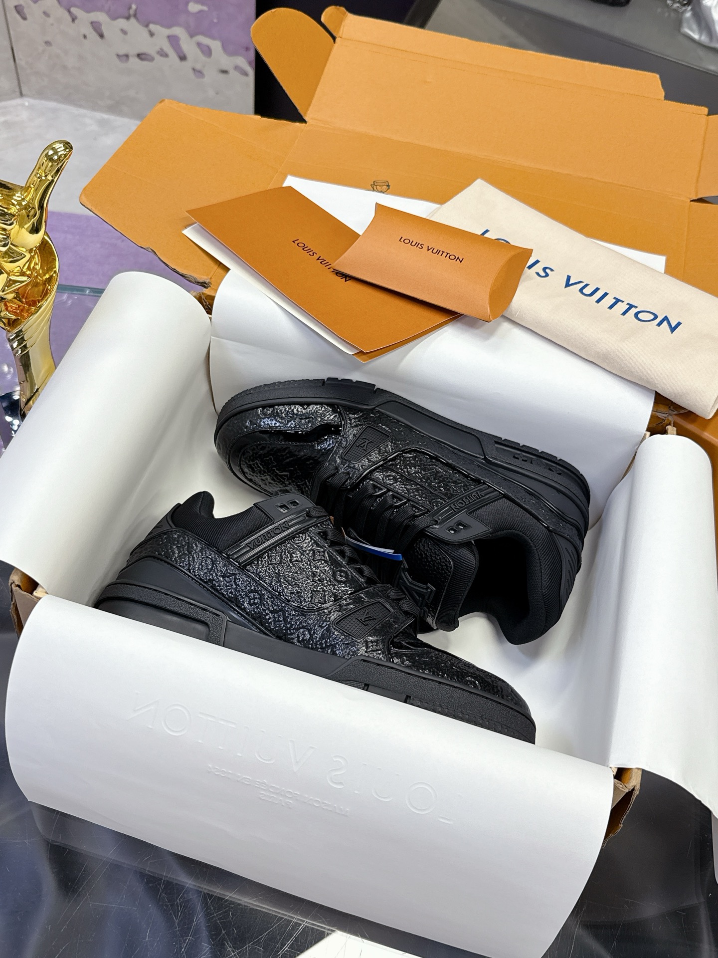 Louis Vuitton 本款LV Trainer运动鞋为亮泽漆面牛皮革压印迷你Monogram图案
