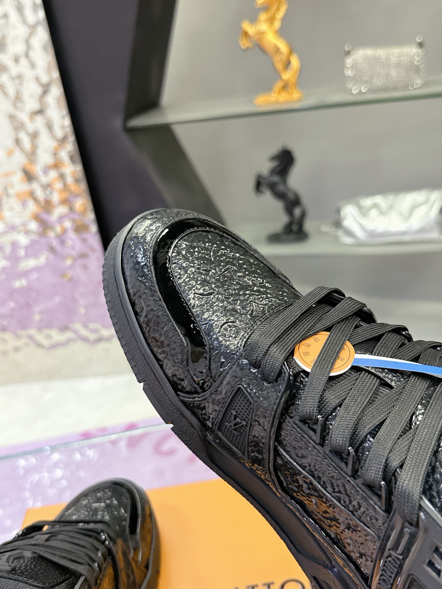 Louis Vuitton 本款LV Trainer运动鞋为亮泽漆面牛皮革压印迷你Monogram图案